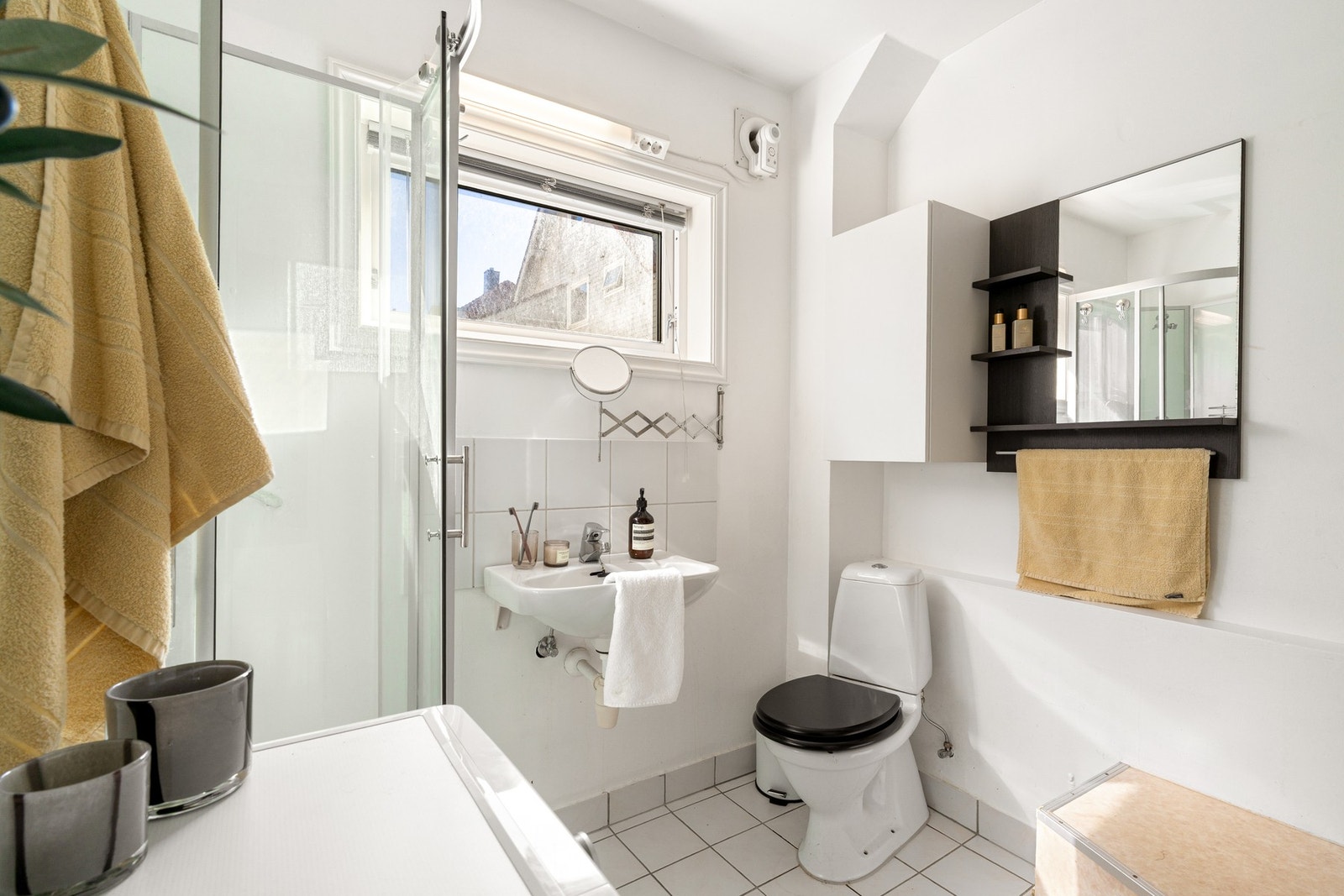 Badet i 1. etasje har flislagt gulv med varmekabler, malte veggflater, dusjkabinett, toalett, servant og mekanisk avtrekk. Galleribilde