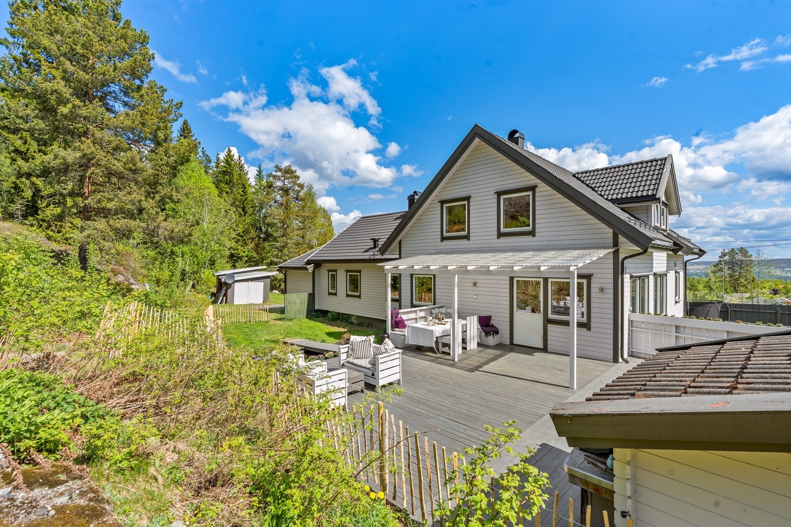 Stor og innbydende terrasse med plass til både spisegruppe, grill og utemøbler. Dette er et perfekt samlingspunkt for familieselskaper og lange sommerdager. Galleribilde