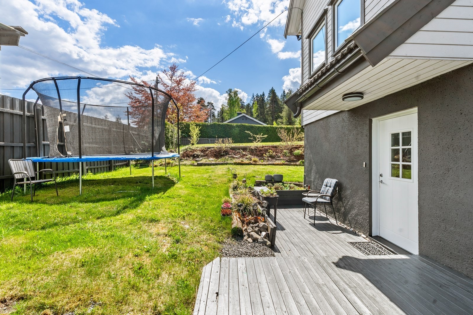 Koselig terrasse ved inngangspartiet med plass til sittegruppe og blomster. En lun plass for morgenkaffe eller en liten pause i solen. Galleribilde