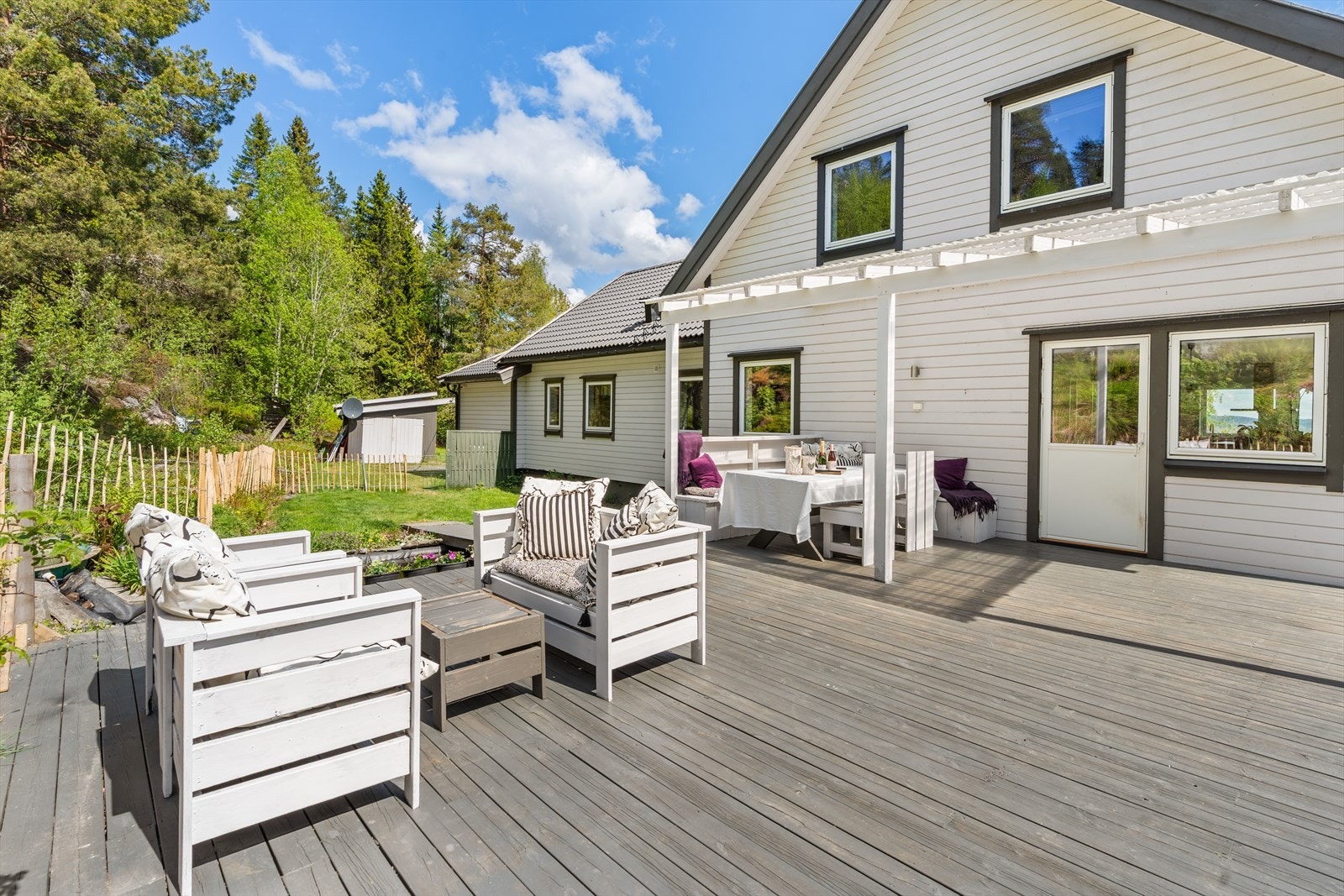 Terrassen har flott kontakt med hagen og gir god plass til både store og små. Her kan familien nyte sol, lek og måltider ute i trykke og hyggelige omgivelser. Galleribilde
