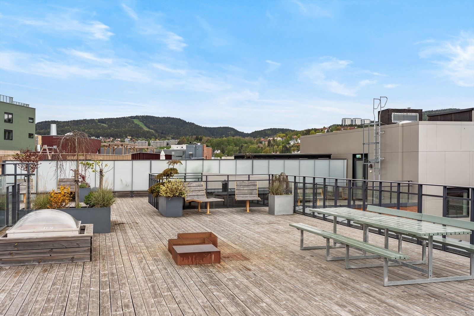 Takterrassen har en pergola og sittegruppe, med utsikt over byen og omkringliggende grøntområder. Galleribilde