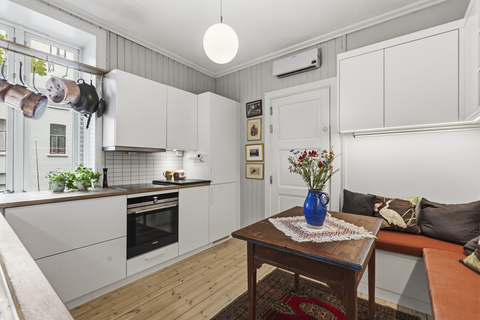 Lys og moderne kjøkkeninnredning bestående av fliser over benk, innfelt downlights under overskap, heltre benkeplate med nedfelt stålkum. Galleribilde