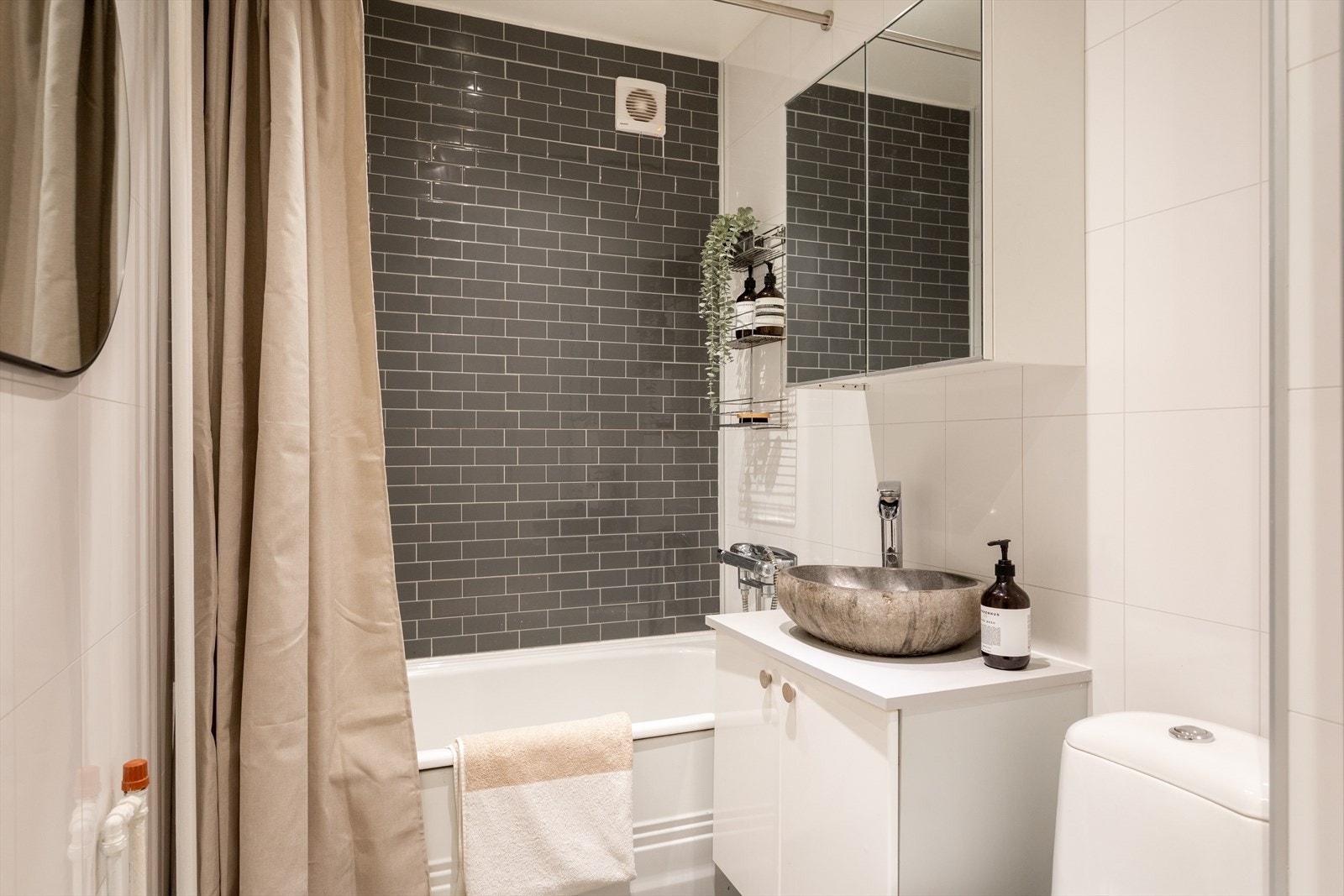 Pent, flislagt baderom med innfelt downlights i himling med malte plater. Galleribilde