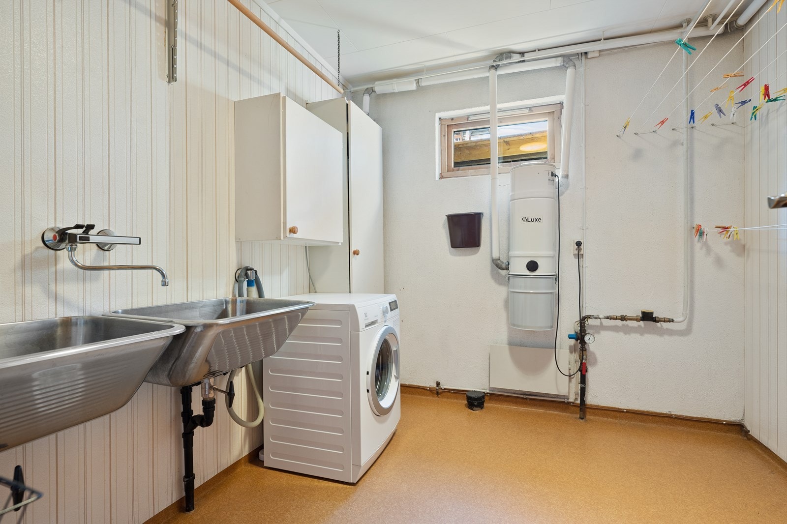 Boligen et separat vaskerom med god plass til klesvask og praktisk oppbevaring. Opplegg for vaskemaskin og varmtvannsbereder, samt både høyskap og veggskap som sørger for nyttig oppbevaringsplass Galleribilde
