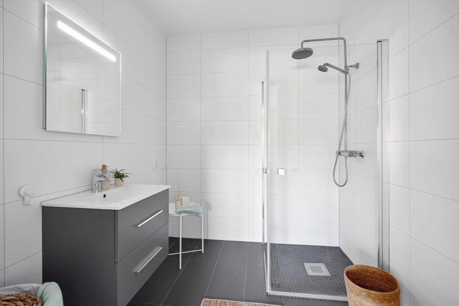 Badet i underetasjen tilknyttet TV-stue med dusj, vegghengt toalett og opplegg for vaskemaskin/tørketrommel. Galleribilde