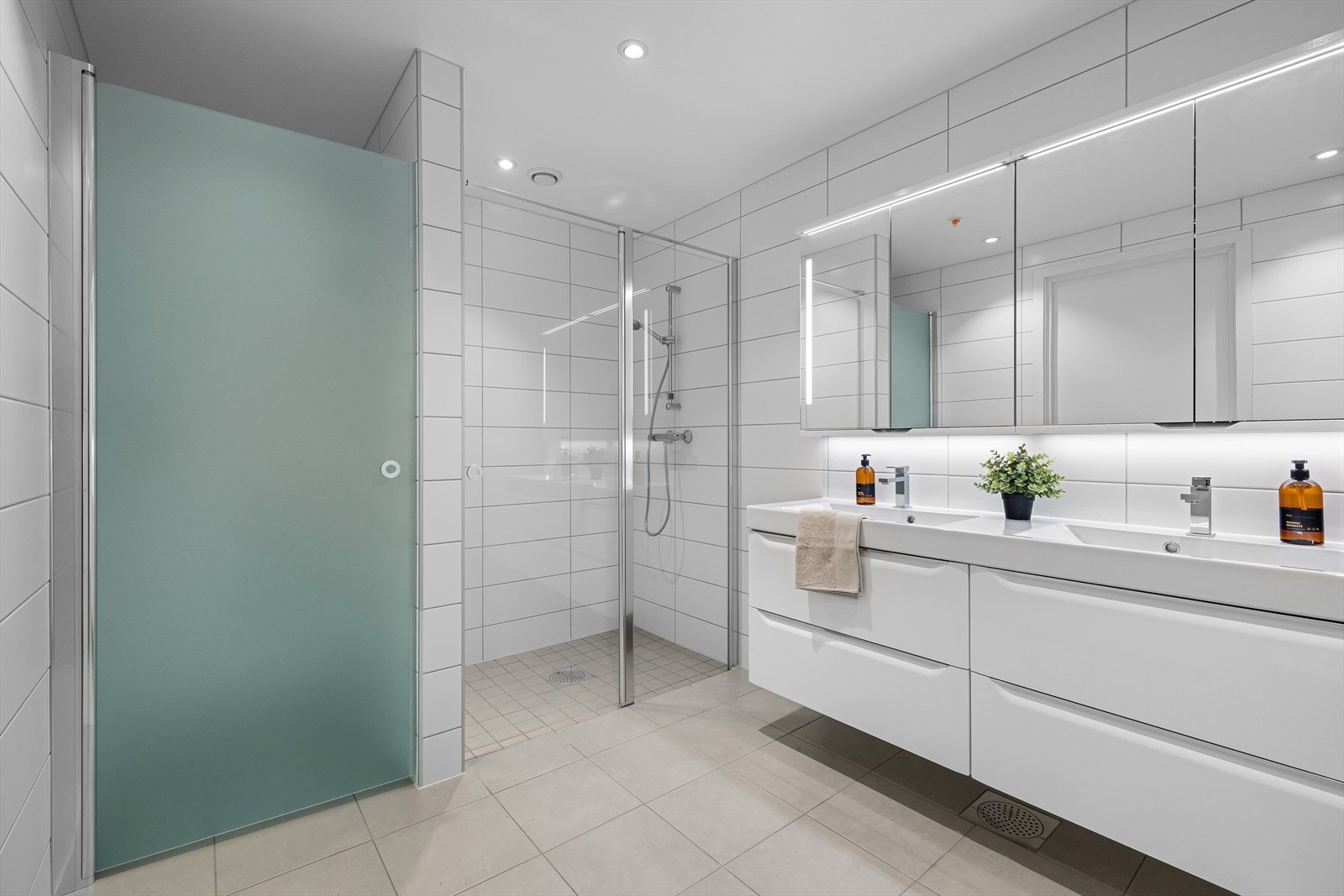 Badet er utstyrt med dusj, toalett og servant med tilhørende baderomsmøblement.