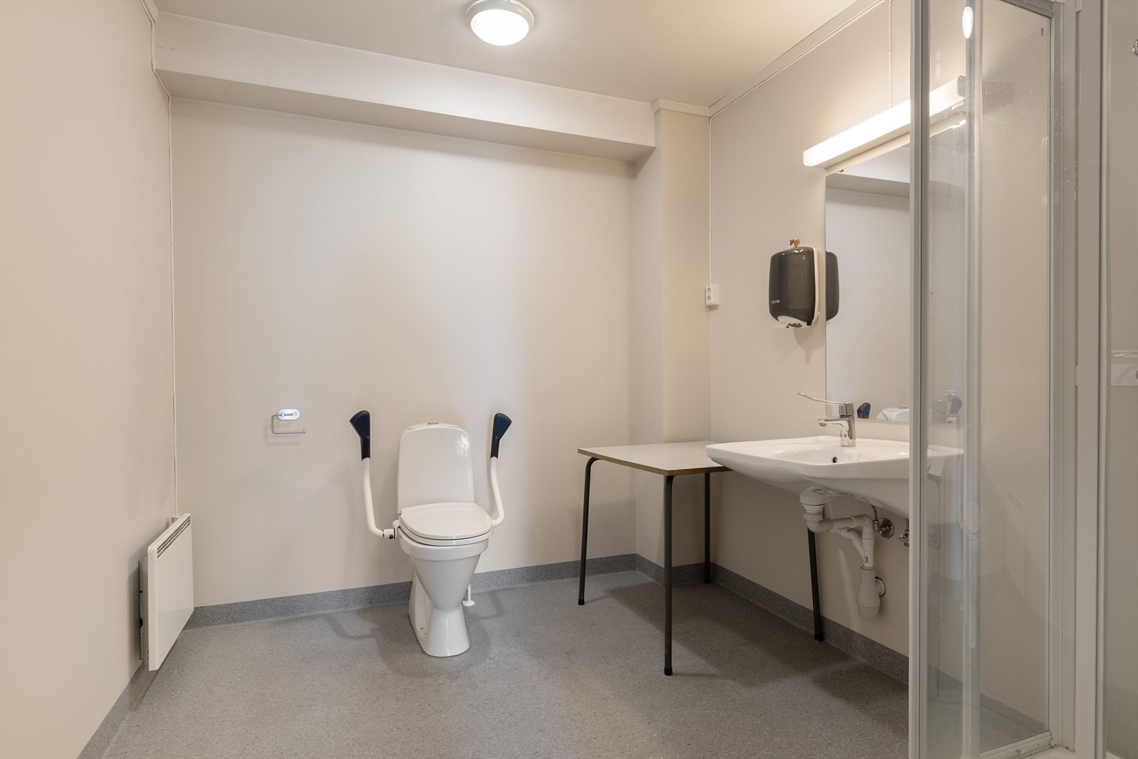 Eldre bad i første etasje innredet med gulvstående toalett, servant og dusjkabinett. Balansert ventilasjon. Galleribilde
