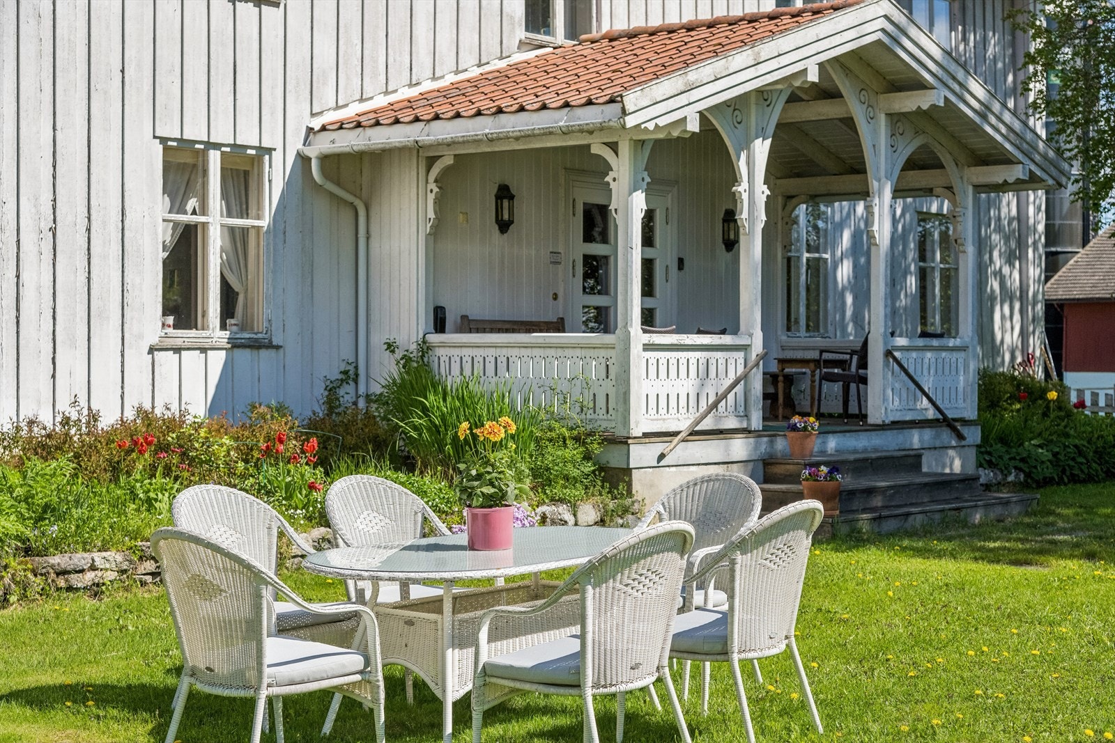 Overbygd inngangsparti på hovedbygningen, med plass for en liten sittegruppe. Galleribilde