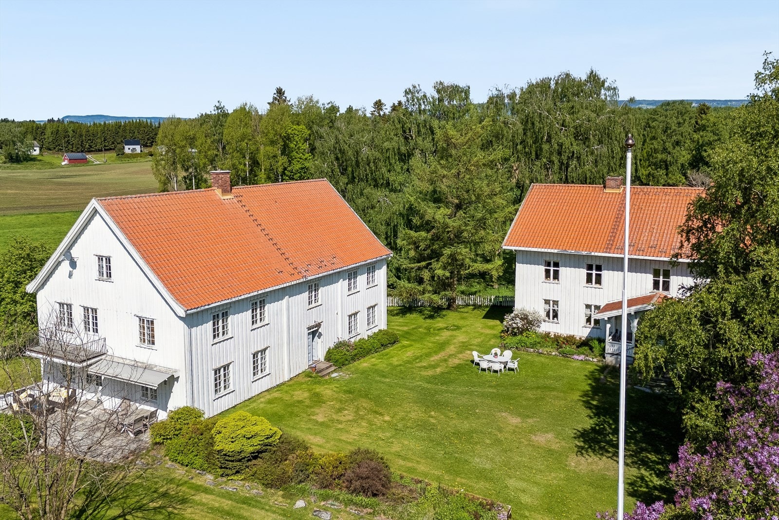 Oversikt over de to eldste bolighusene på tunet, hovedbygningen til høyre og kårboligen til venstre. Galleribilde