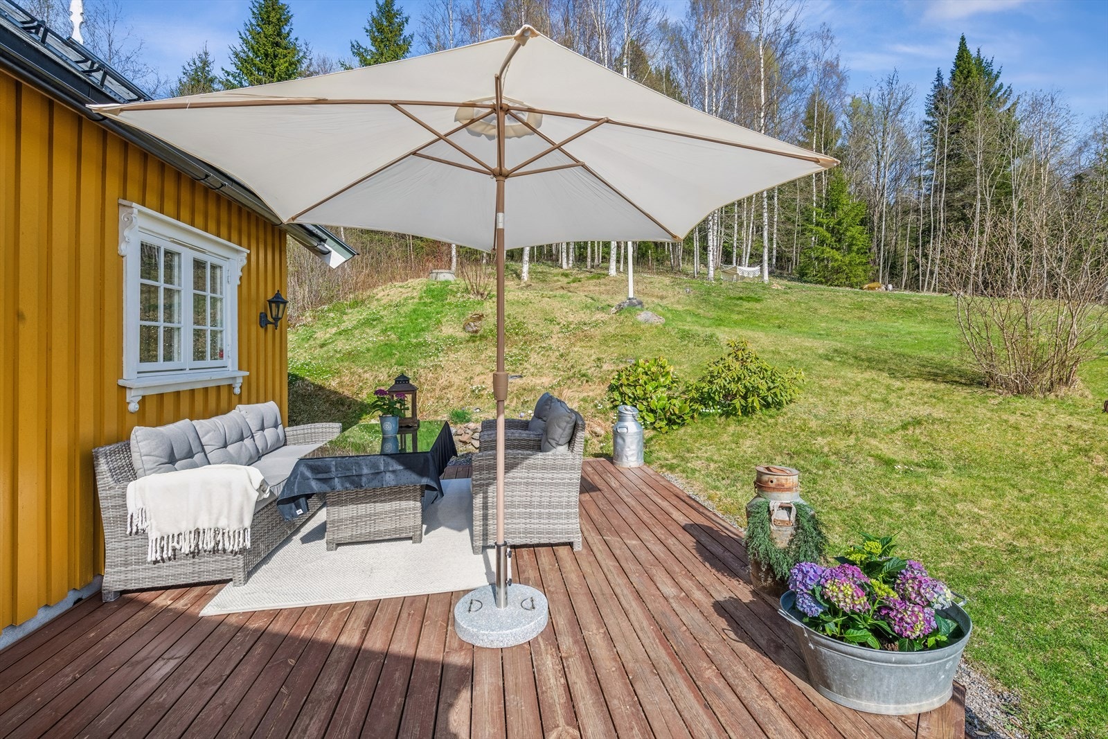 En markterrasse ved inngangspartiet gir en fin uteplass på baksiden av huset. Galleribilde
