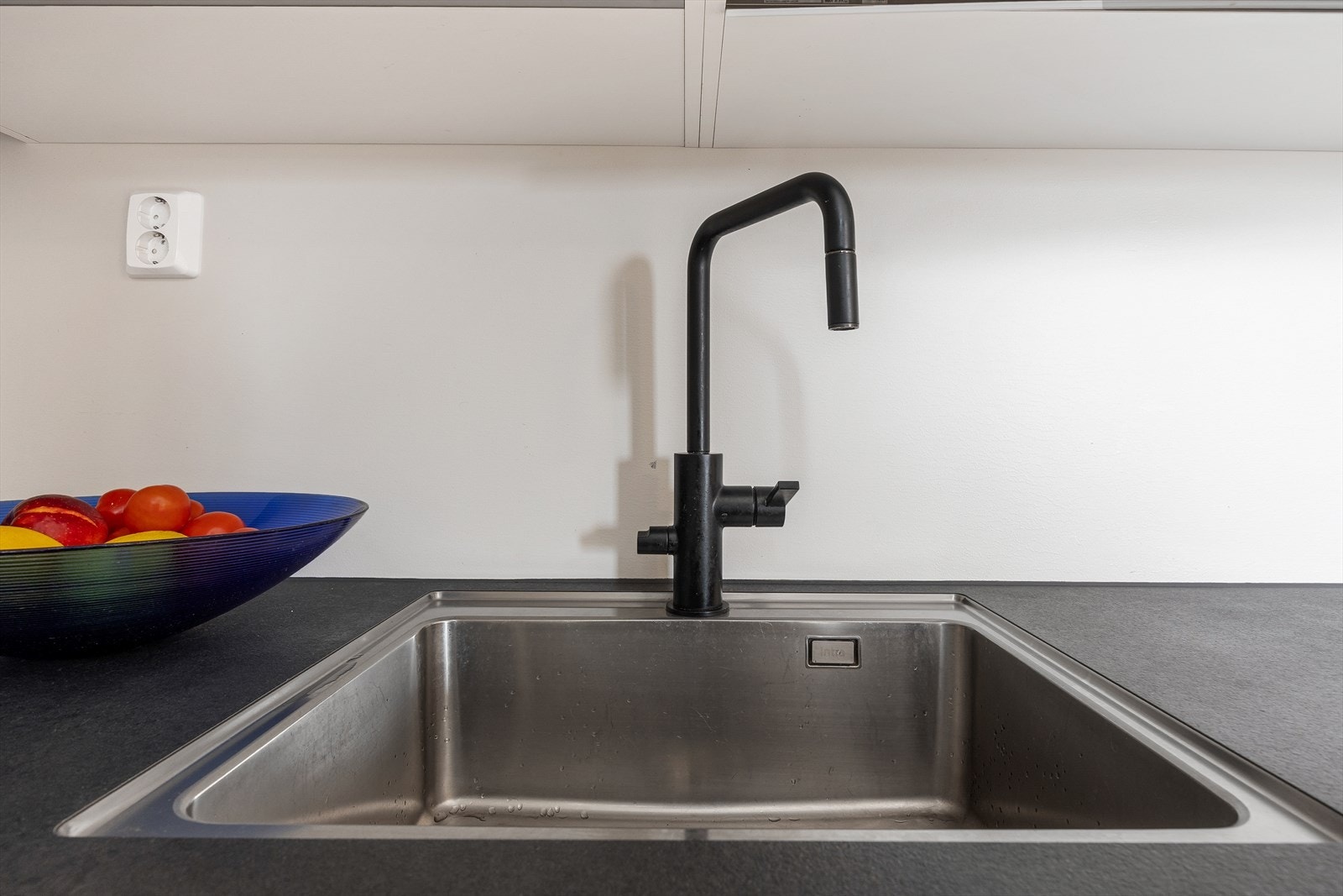 Detalj fra kjøkkenet med underlimt stålkum i en slitesterk laminatbenkeplate. Galleribilde