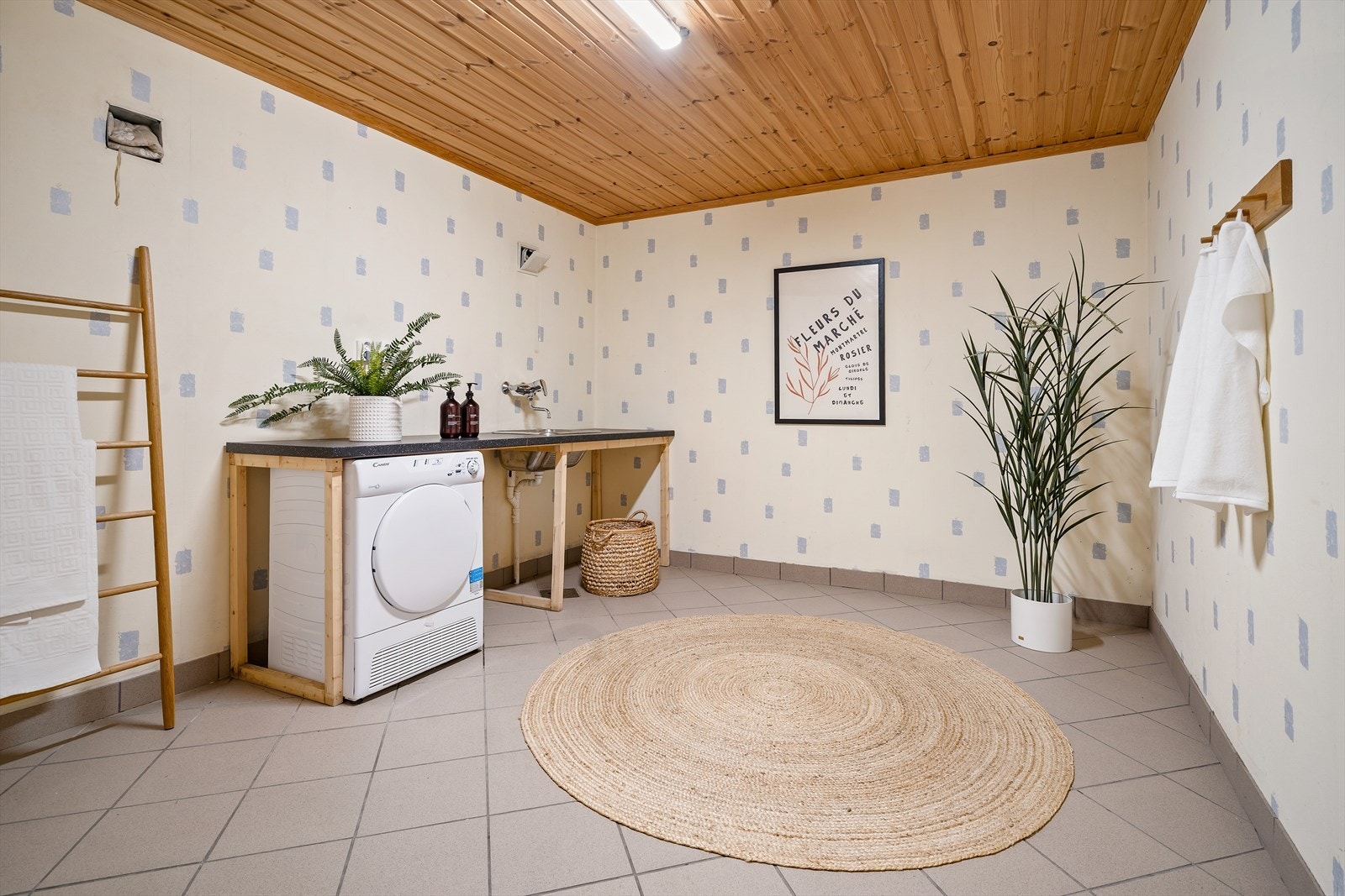 Stort og praktisk vaskerom med flislagt gulv, god benkeplass og opplegg for vaskemaskin. Galleribilde