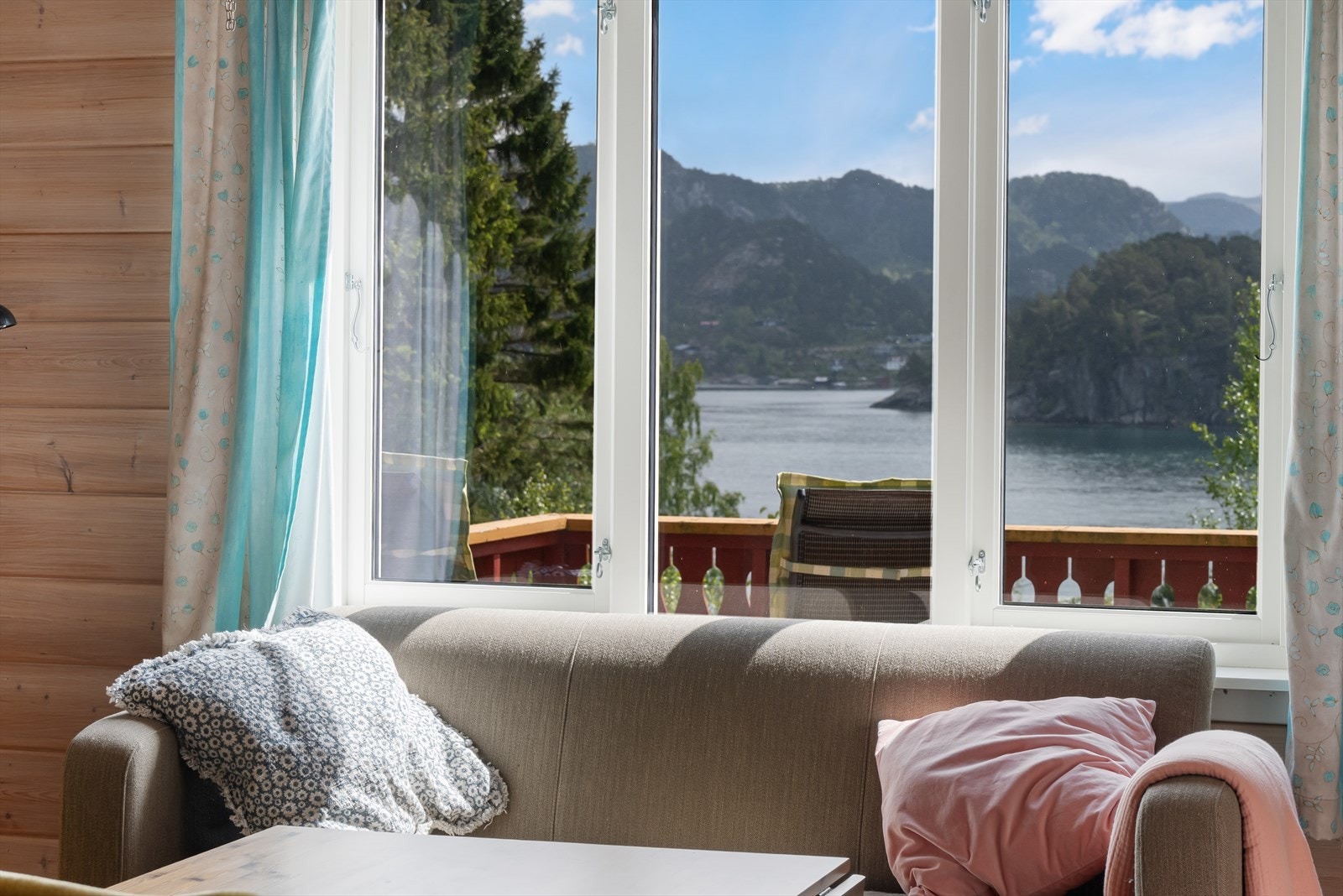 Fra stuen er det utsikt mot sjøen gjennom vinduer som kan nytes fra sofakroken. Galleribilde