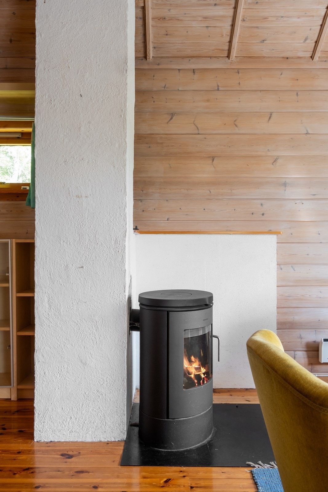 En peis ved teglsteinspipen fra byggeåret gir ekstra varme og hygge i stuen. Galleribilde