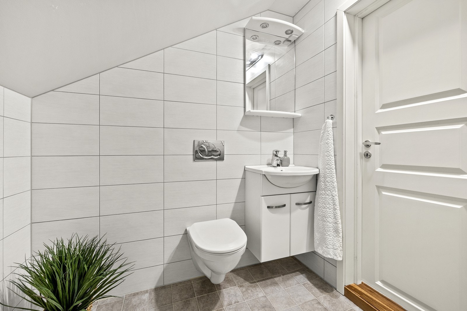 Badet er utstyrt med dusjnisje, vegghengt wc og servantinnredning med underskap. Galleribilde