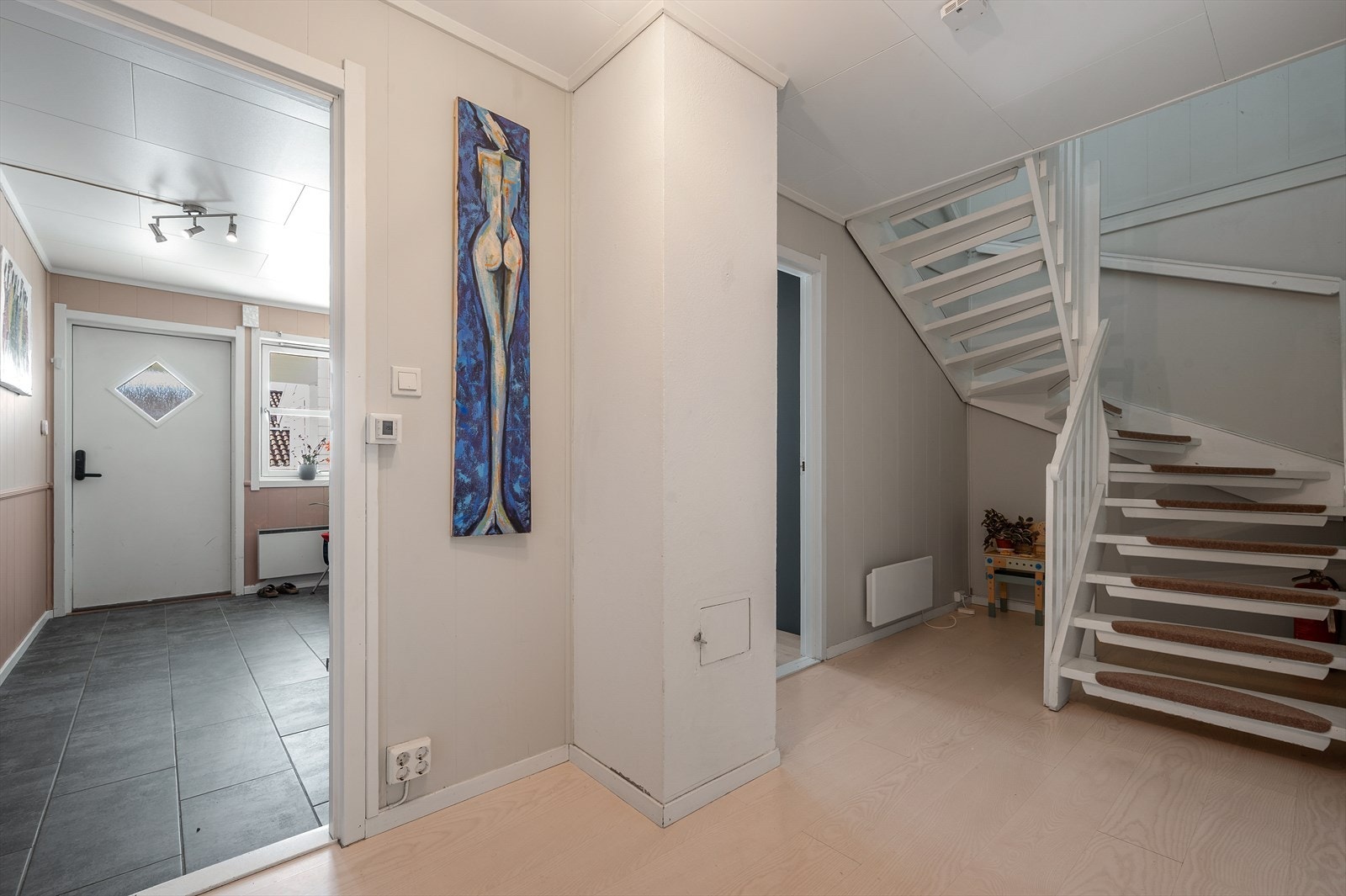 Entréen har fliser på gulvet og en romslig skyvedørsgarderobe for oppbevaring. Galleribilde