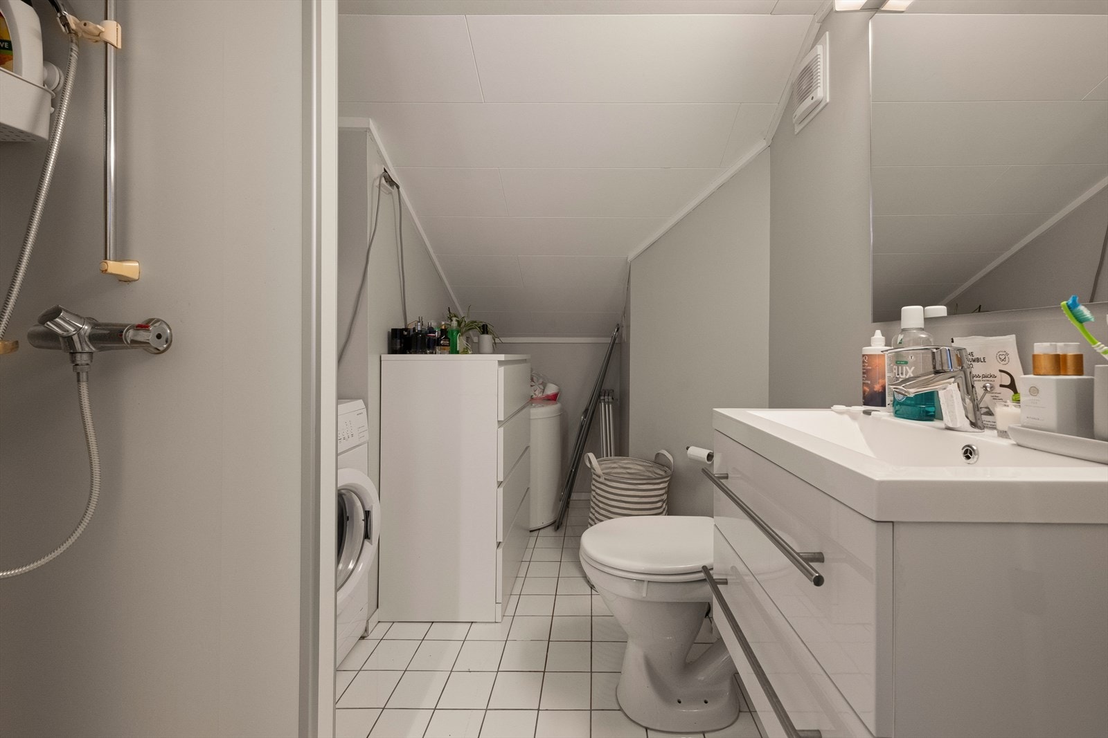 Badet i hybel-delen har flislagt gulv, toalett, dusjnisje og opplegg for vaskemaskin. Galleribilde