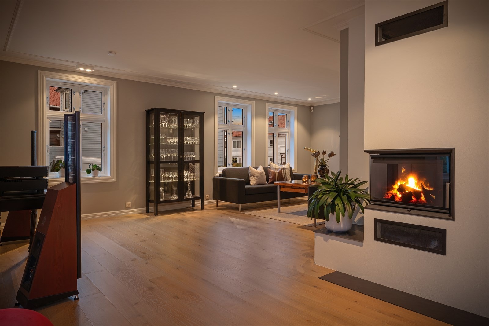 Stuen i kveldsstemning, med peisen som et sentralt element. Galleribilde