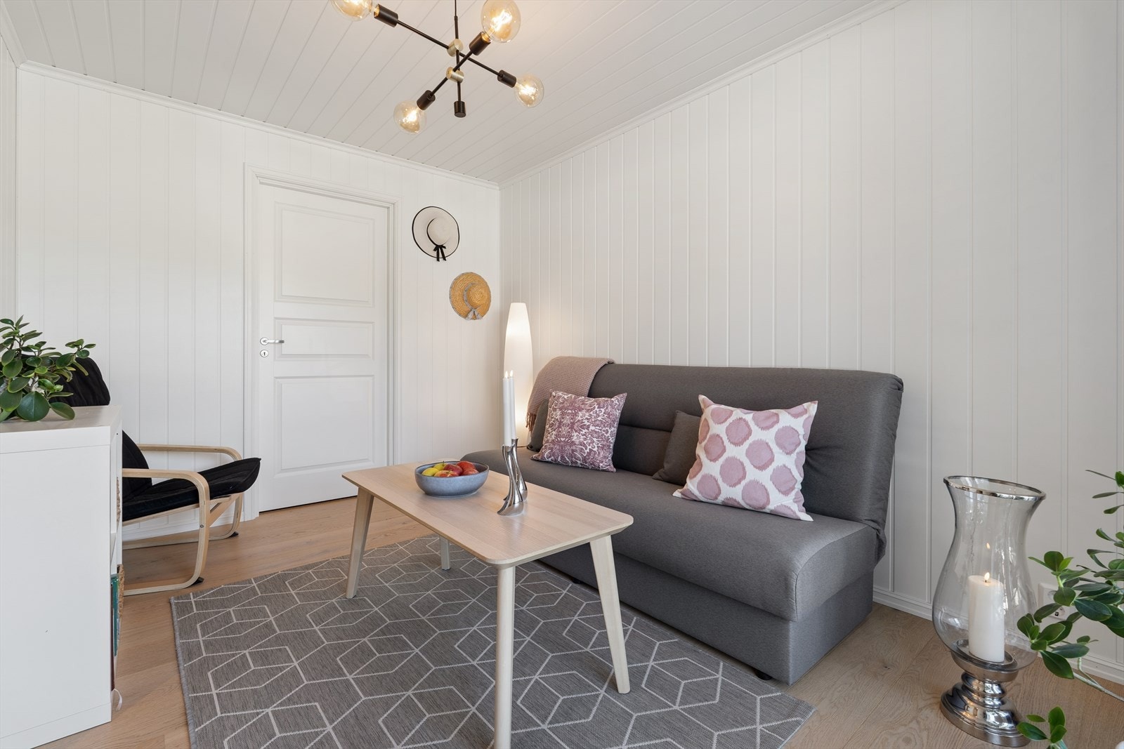 Rommet har malte panelplater på veggene og god plass til en sofagruppe. Galleribilde