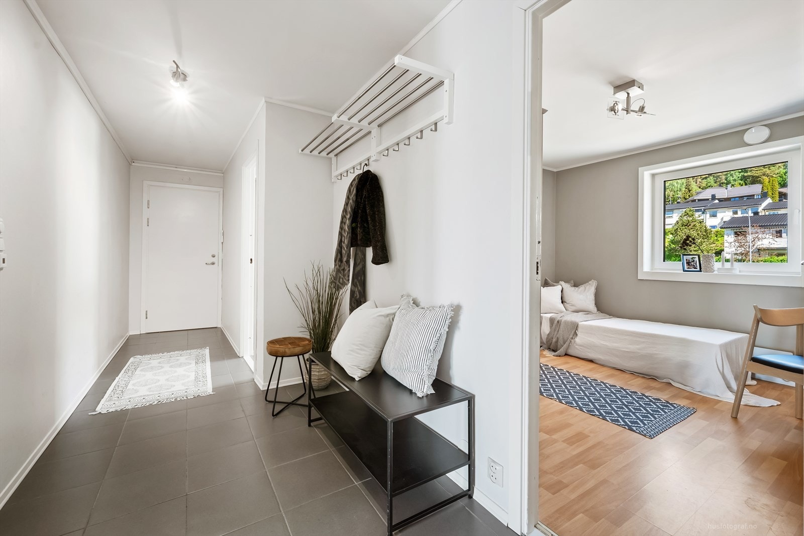 Flislagt entré med god plass til å henge fra seg yttertøyet. Leiligheten har også en innvendig bod. Galleribilde