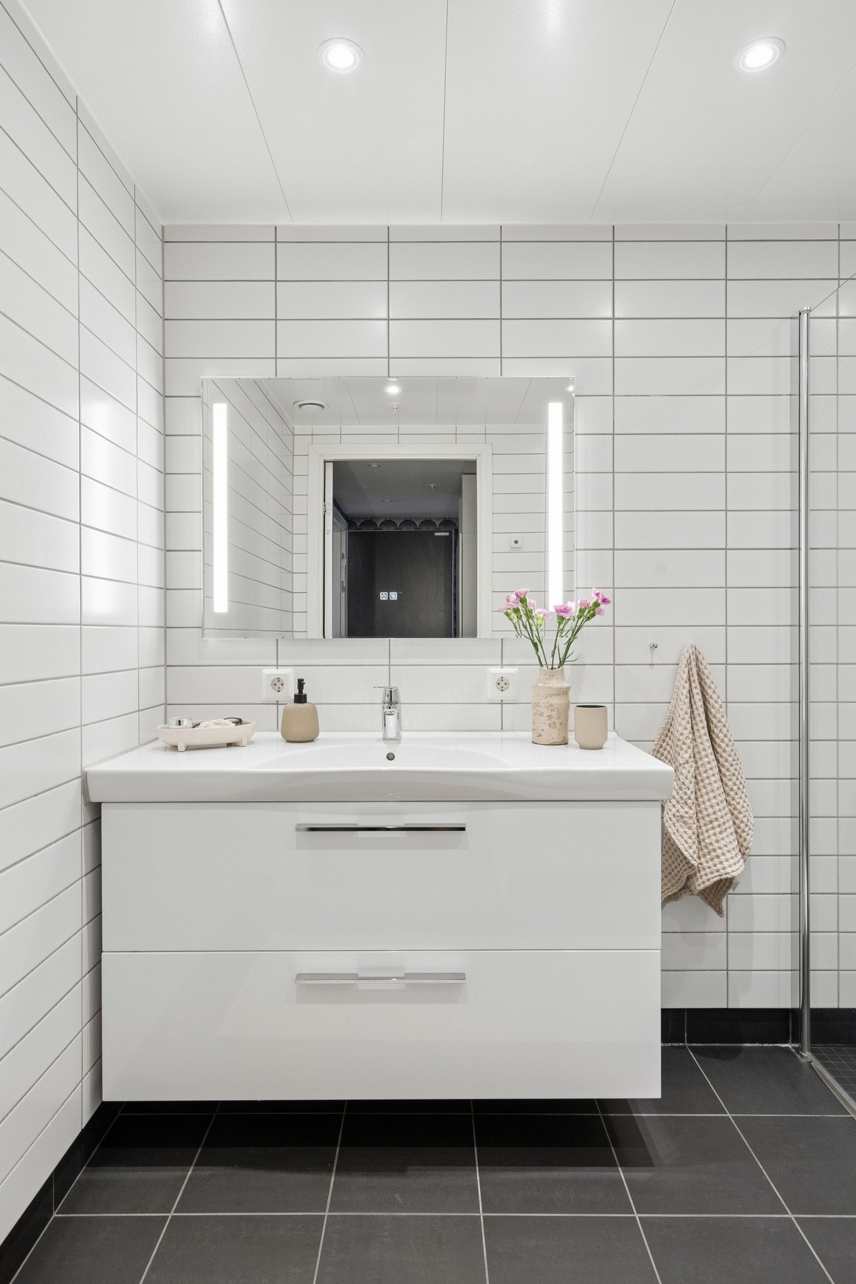 Baderomsinnredning med heldekkende servant og speil med integrert belysning. Galleribilde