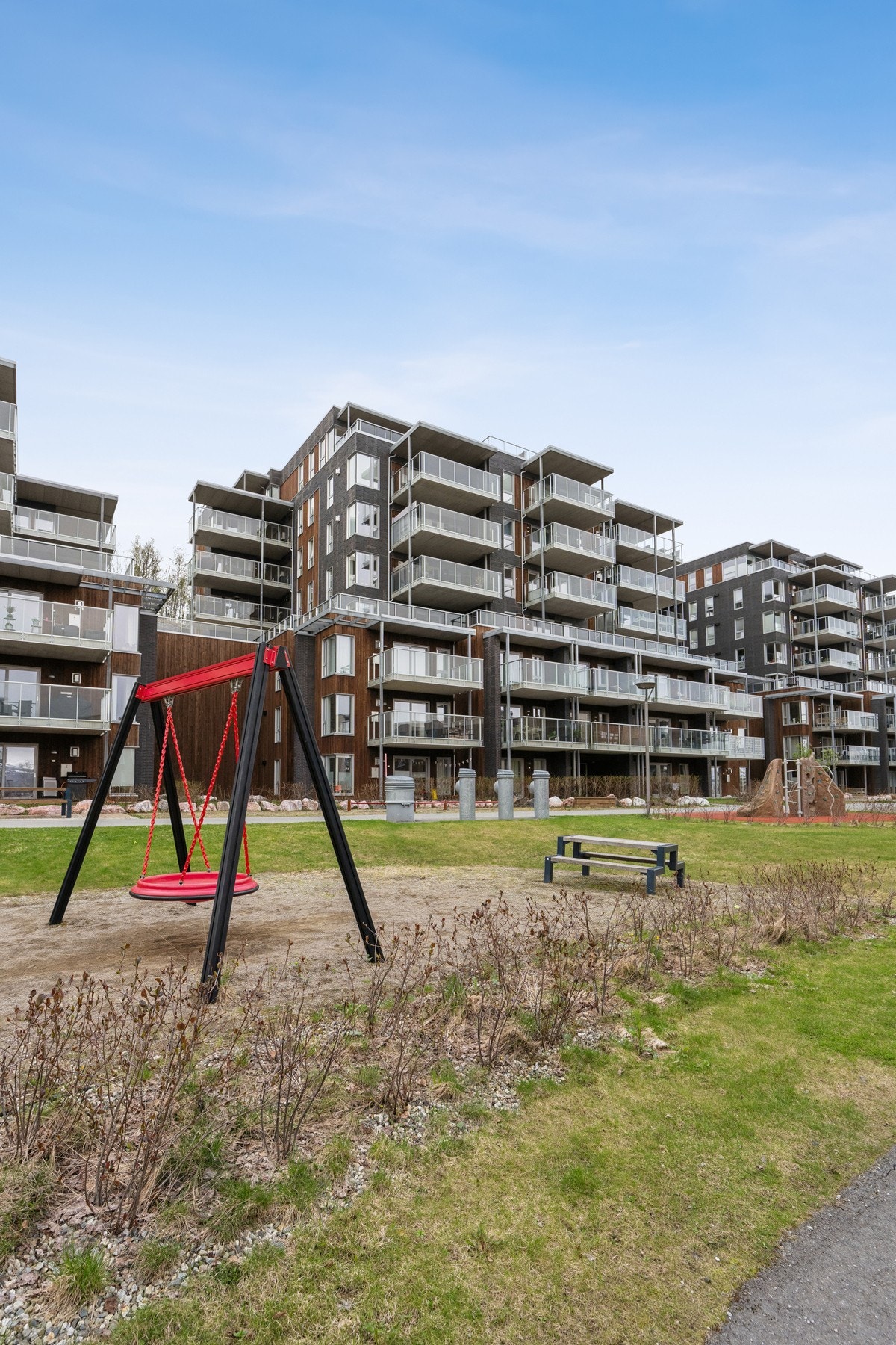 Bygget har en kombinasjon av stående trekledning og betongelementer i fasaden. Galleribilde