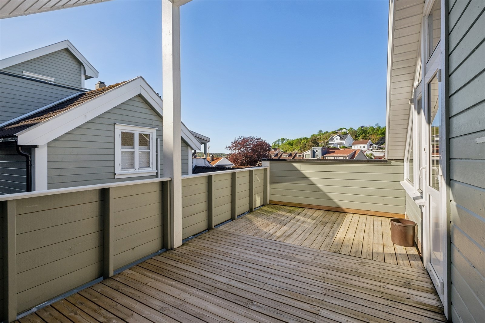 Fra stuen er det utgang til en romslig terrasse på 18 m²med trebord. Terrassen gir utsikt over hustak og omgivelsene rundt. Galleribilde