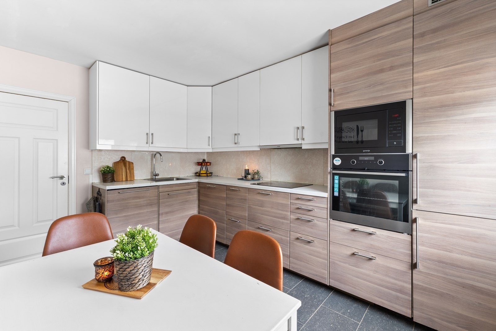Kjøkkenet er innredet med glatte fronter og laminat benkeplate. Kjøkkenet er godt utstyrt med integrert oppvaskmaskin og kjøl-/fryseskap, samt nedfelt platetopp, innebygd stekeovn og mikrobølgeovn. Galleribilde