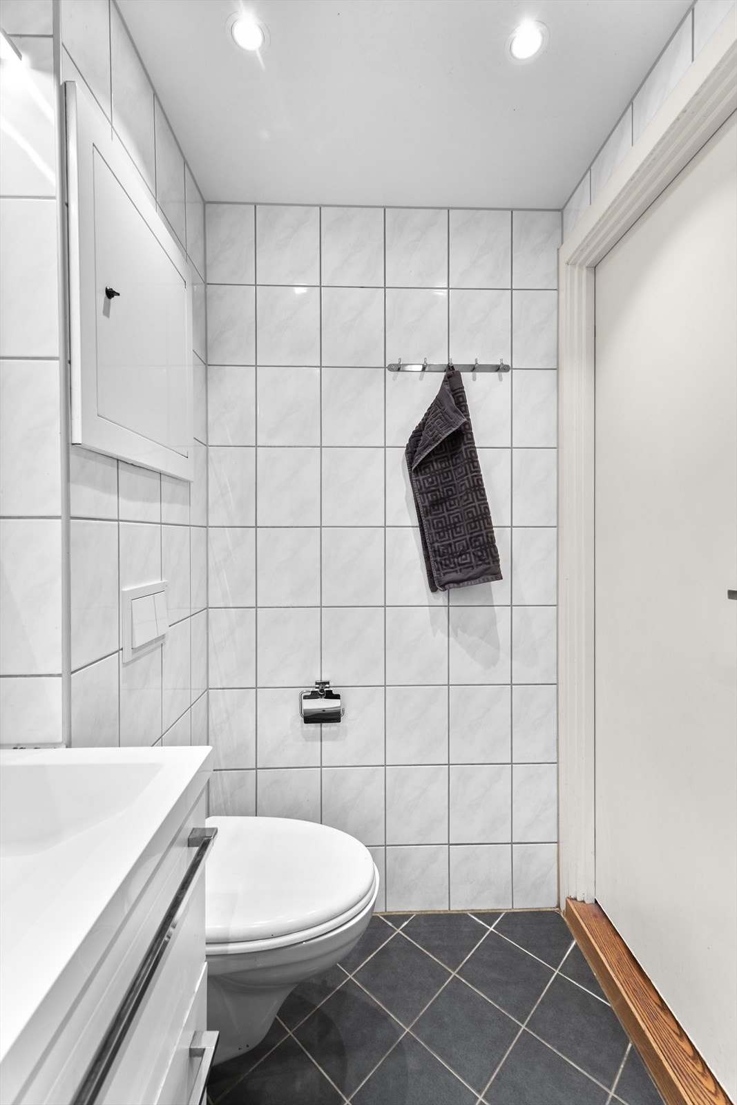 Gulvet er utstyrt med elektriske varmekabler som bidrar til god komfort. Malt himling med innfelte downlights gir god belysning i rommet. Badet har naturlig ventilasjon. Galleribilde