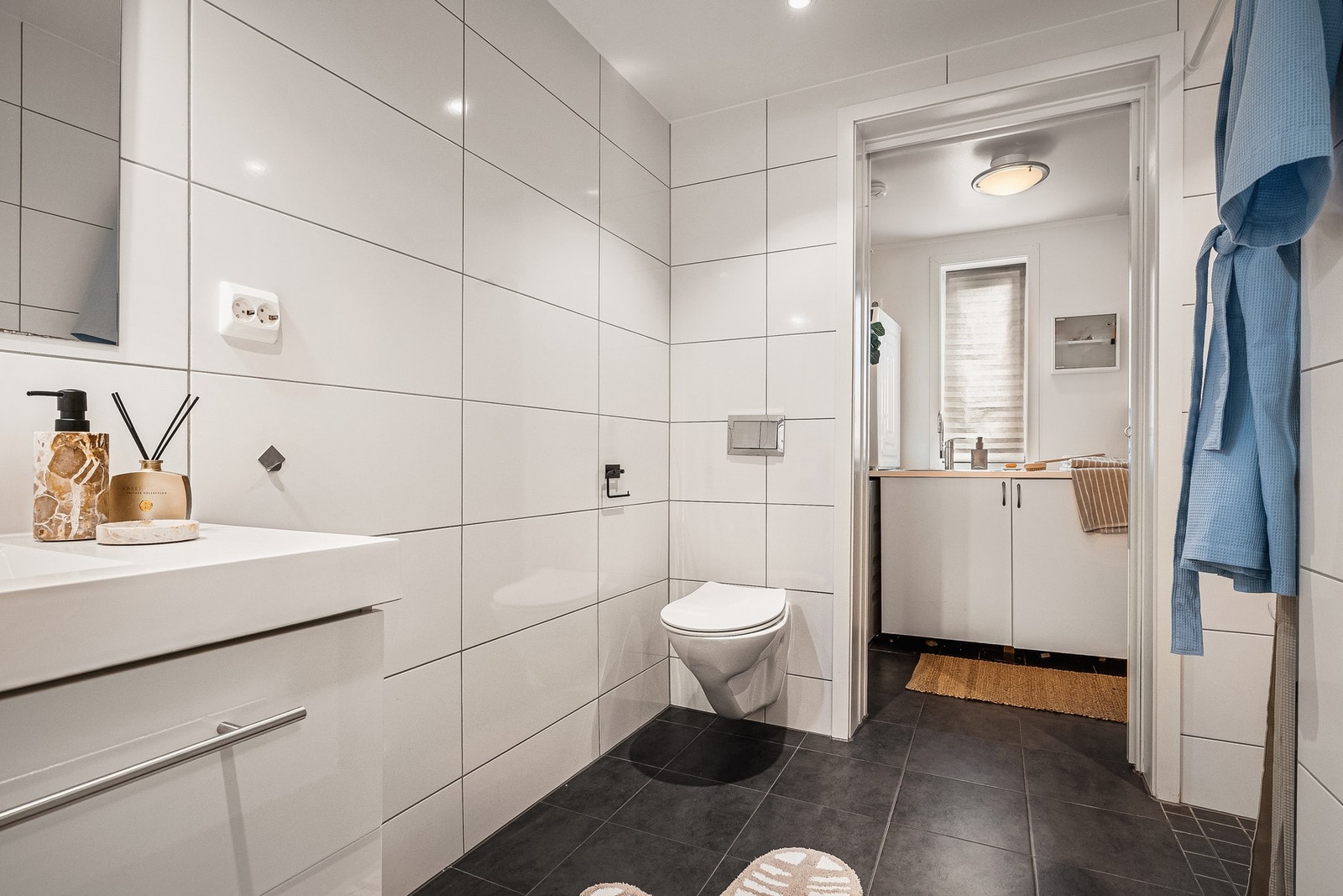 Badet i første etasje har direkte tilknytning til vaskerommet med praktisk skyvedør mellom dem Galleribilde