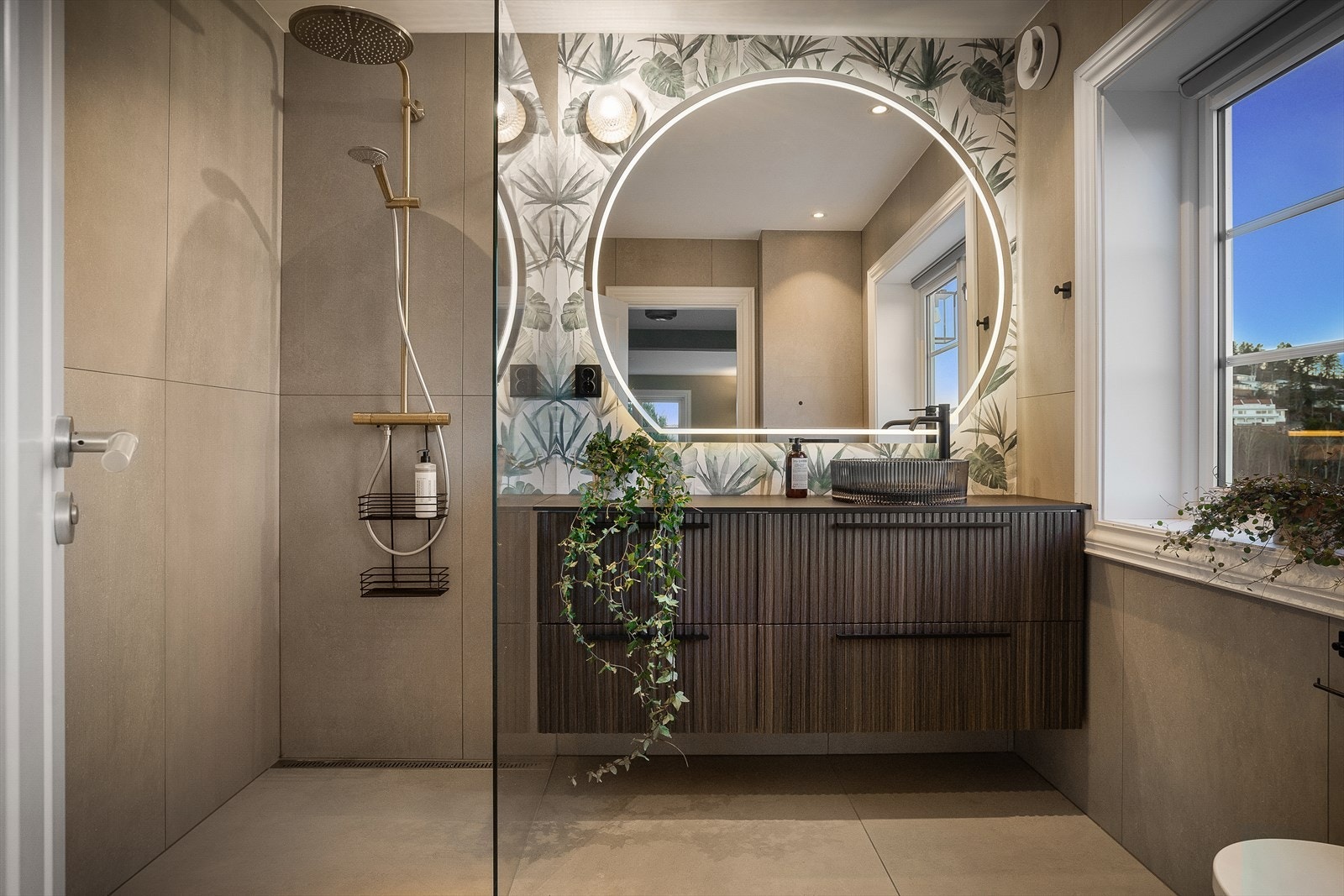 Det ene badet ligger i første etasje og var nytt i 2020. Rommet har en gjennomført, lekker stil i lune gråbrune fargetoner kombinert med de små, viktige detaljene i sort og gull. Galleribilde