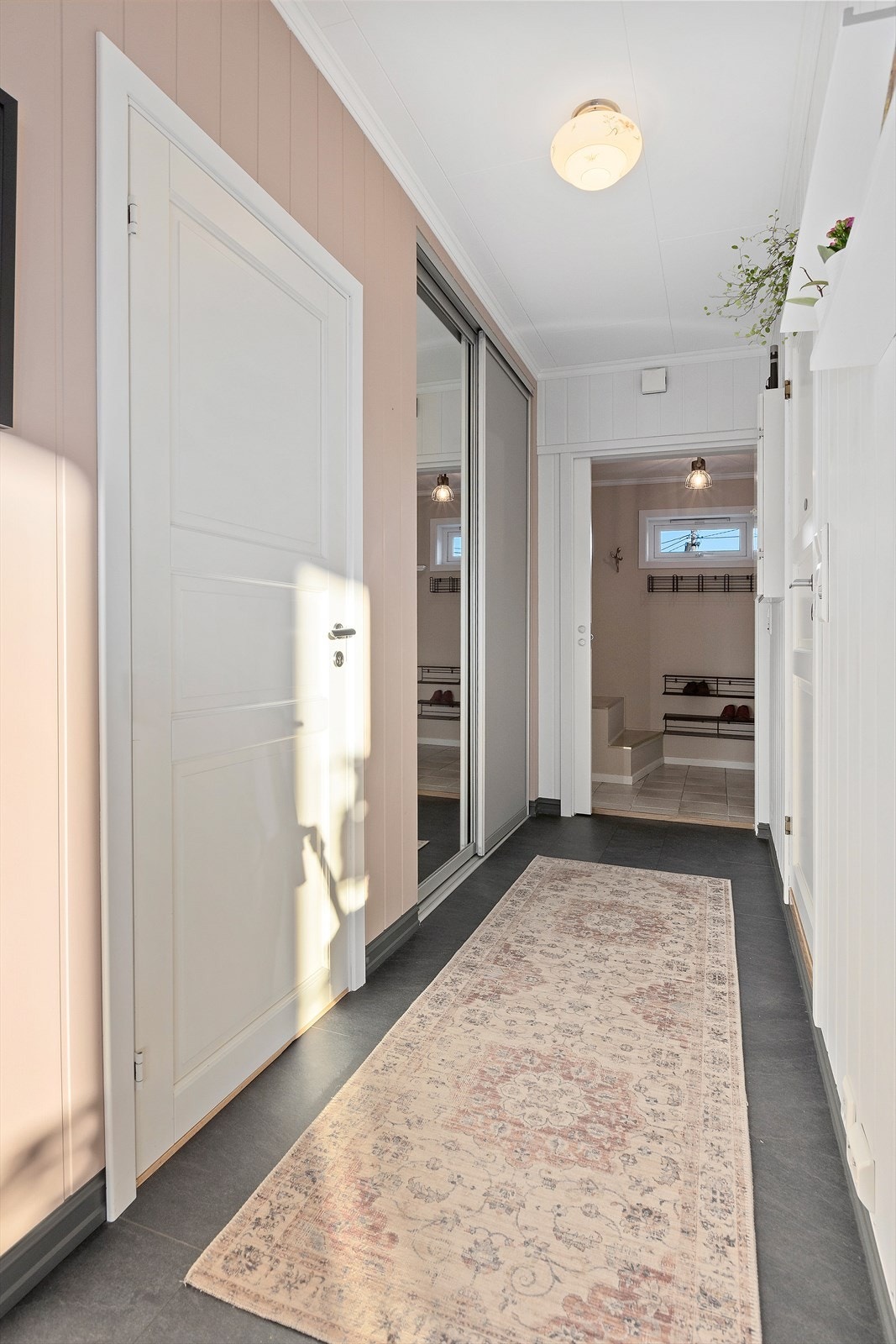 Fra entré kommer man inn i en mellomgang utstyrt med oppbevaring i praktisk skyvedørsgarderobe. Galleribilde
