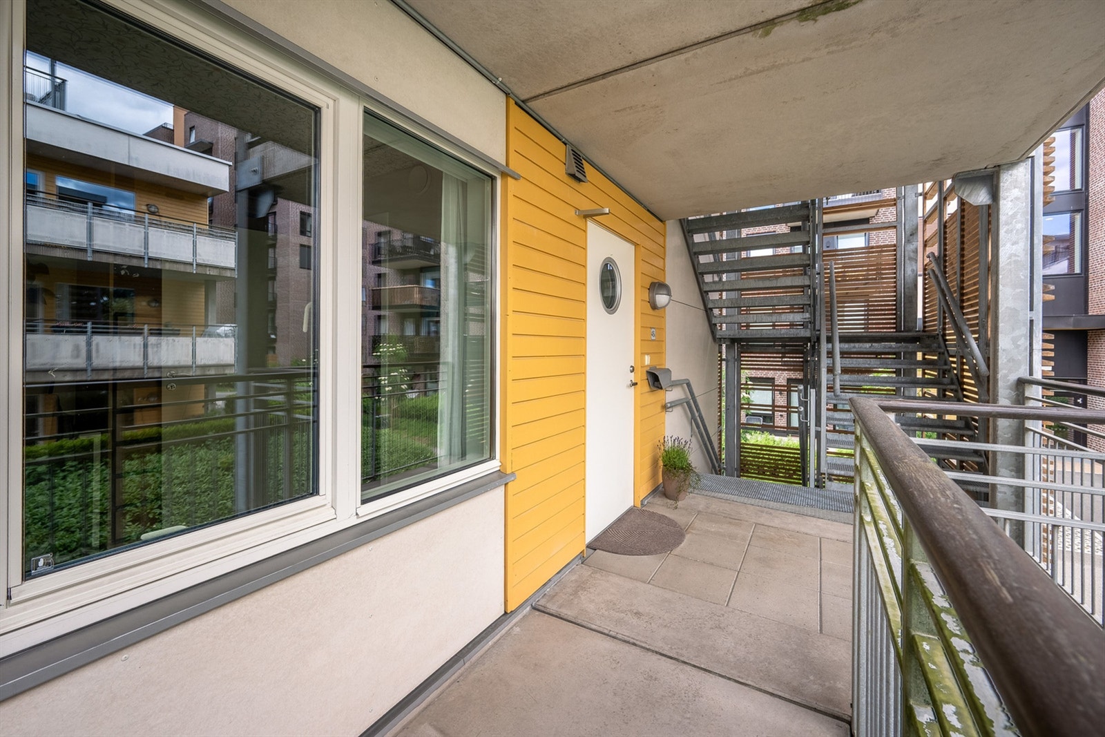 Boligen ligger på enden av svalgangen. Trappen du ser er kun en branntrapp, så det er i praksis ingen som går på utsiden av denne leiligheten i det daglige. Galleribilde