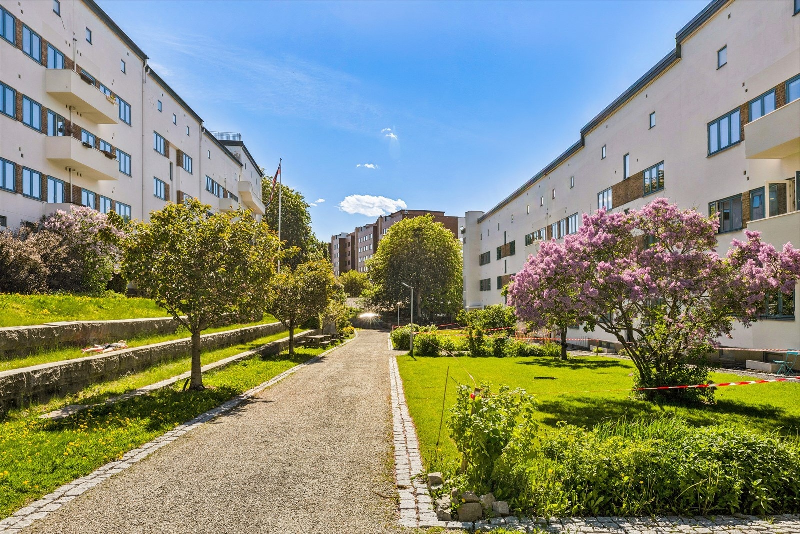 En frodig og velstelt bakgård som beboerne kan nyte som sin egen - her er det god plass til både lek, grilling og rolige kvelder utendørs. Galleribilde
