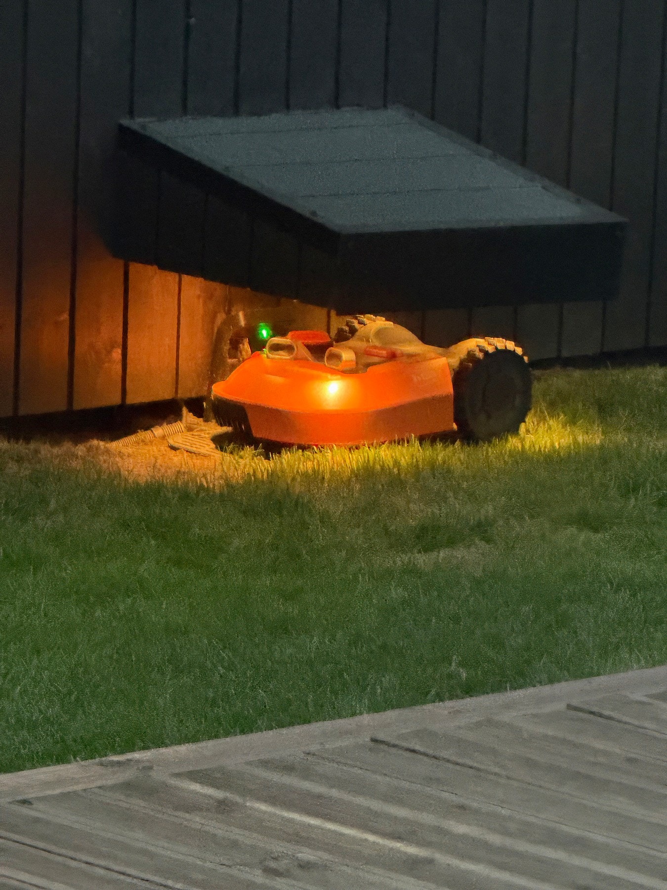Hagen har robotgressklipper, lade stasjonen har overbygg med belysning. Galleribilde