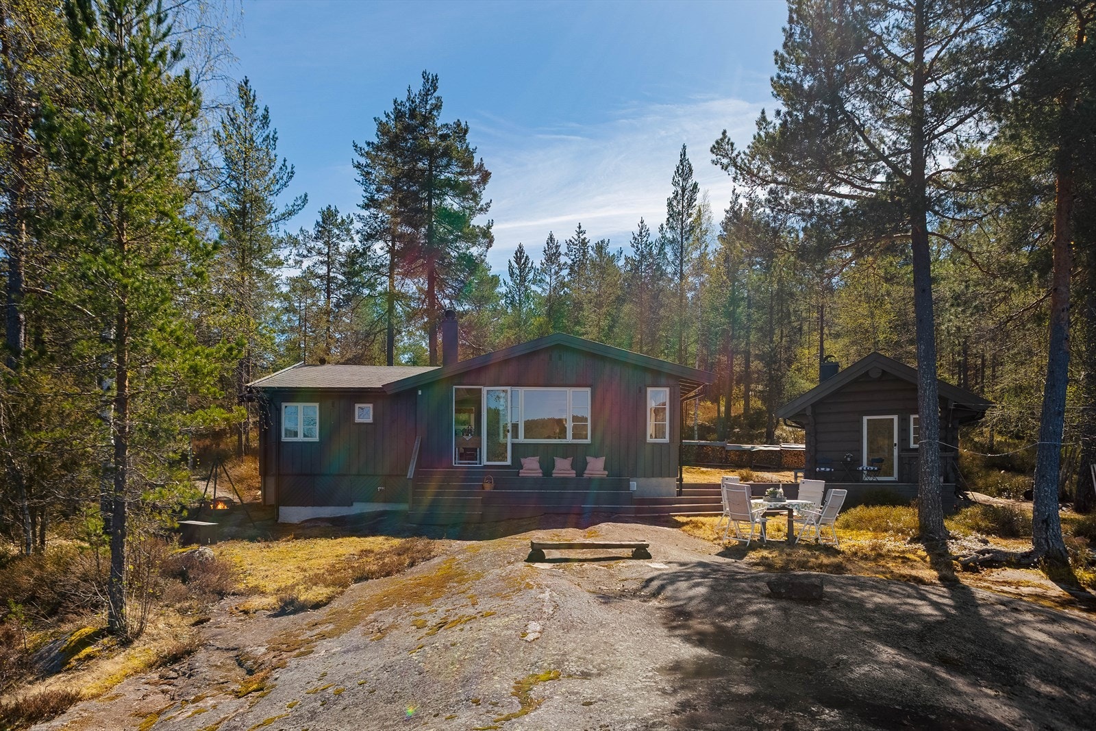 Eiendommen består av en romslig, eiet tomt på 1 680 m², utformet som en idyllisk naturtomt med skrånende terreng, vakre svaberg og karakteristiske furutrær som gir en lun og ekte hyttefølelse. Galleribilde