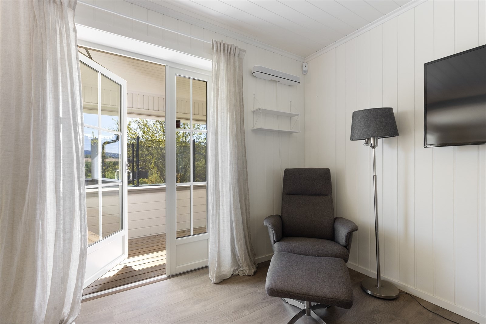 Verandadøren i malt tre med 2-lags isolerglass gir direkte adkomst til den takoverbygde verandaen. Galleribilde