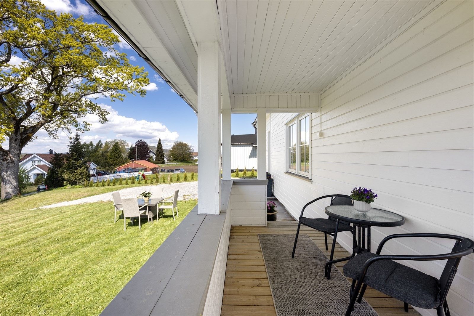 Verandaen er bygget i trykkimpregnert trevirke og strekker seg langs deler av bygningens vestre og søndre side, med nedgang til hagen. Galleribilde