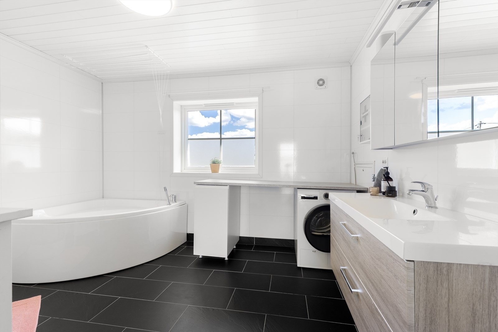 Kombinert bad- og vaskerom med standard fra 2018. Badet har flislagt gulv med varmekabler og våtromsplater i flisimitasjon på vegger. Galleribilde