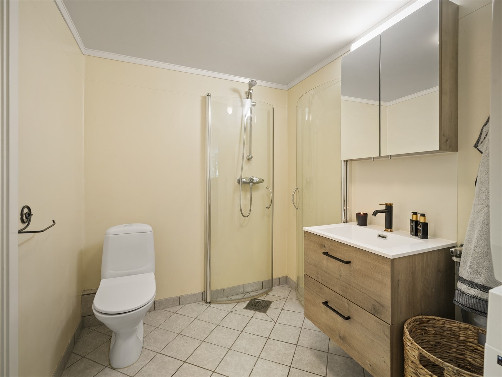 Badet har flislagt gulv med elektriske varmekabler og er innredet med servantinnredning, toalett, dusjhjørnet samt opplegg for både vaskemaskin og tørketrommel. Galleribilde