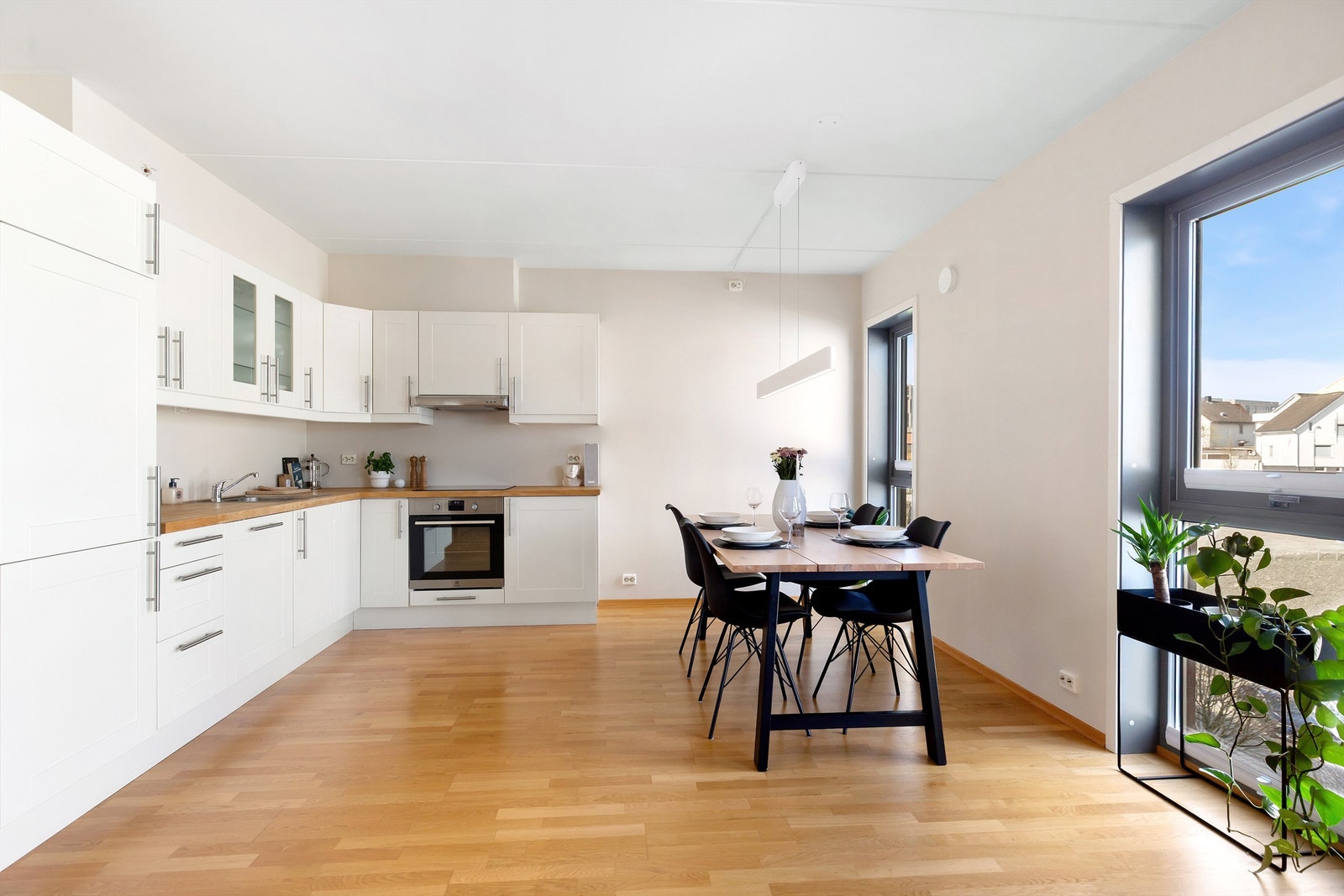 Kjøkkeninnredning med benkeplate i tre og godt med skapplass. Galleribilde