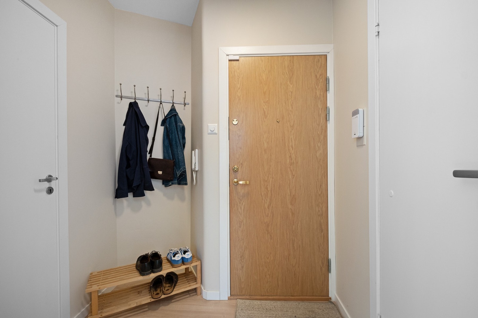Velkommen inn i en lys og innbydende entré! Her får du et stilrent førsteinntrykk med pene laminatgulv og malte vegger i tidløse farger. Galleribilde