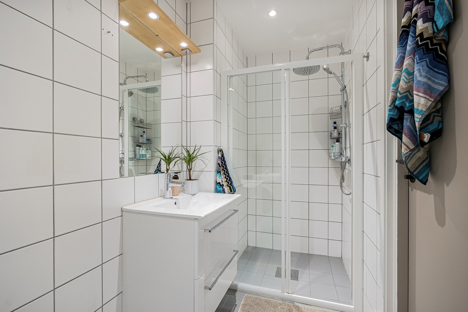 Badet er innredet med dusjnisje med skyvedør og termostatstyrt dusjbatteri i krom med både hånd- og regnfallsdusj. Galleribilde