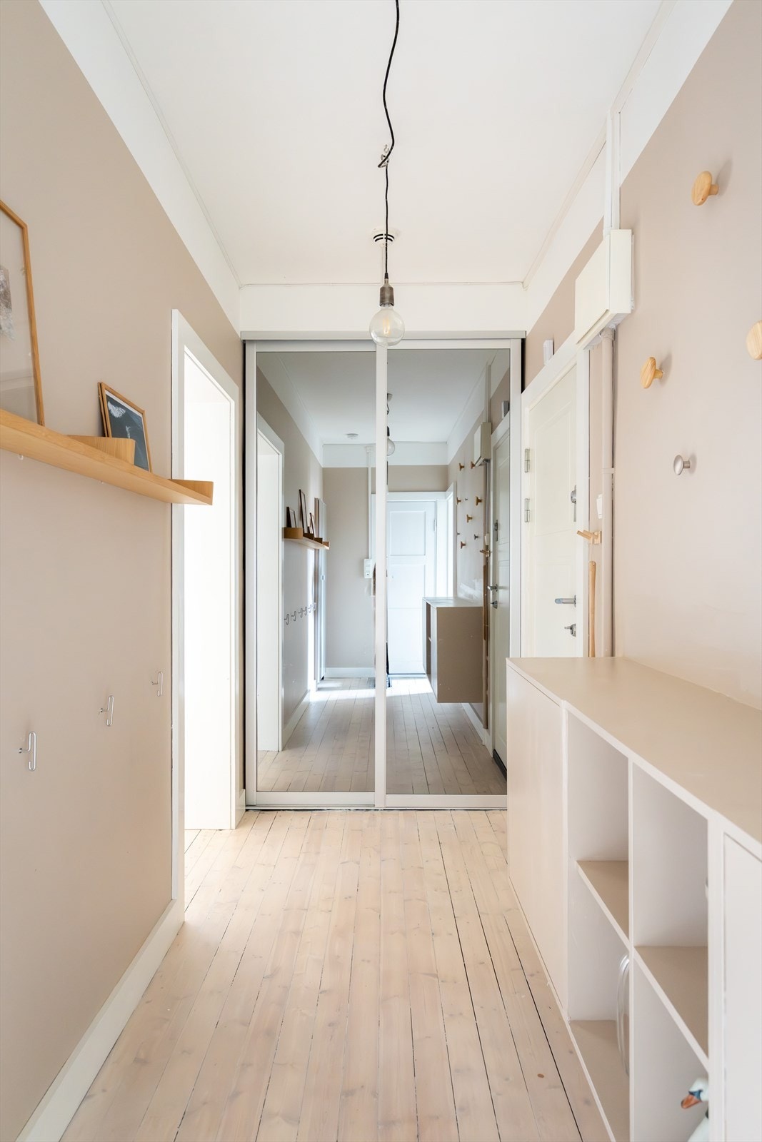 Oppbevaringsløsningene er både praktiske og stilrene, med skyvedørsgarderobe med speilfronter samt vegghengt hylle med skap. Galleribilde