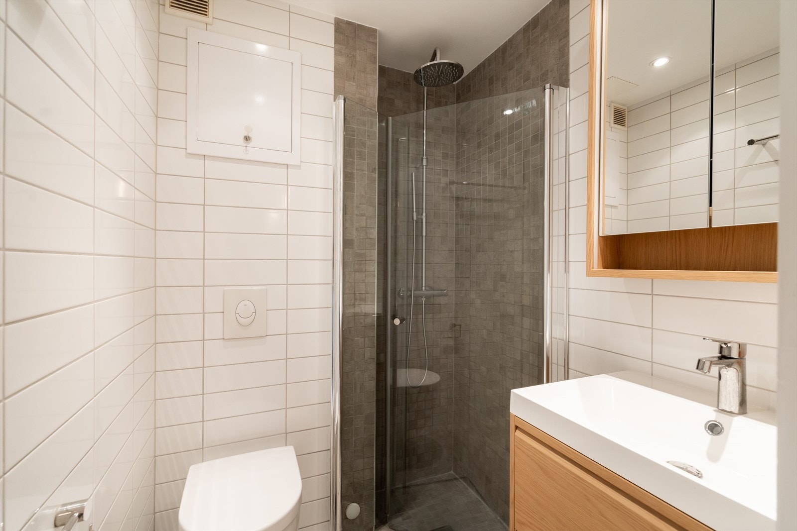Badet er videre utstyrt med vegghengt toalett, downlights samt dusjhjørne med regnfallsdusj og innfellbare glassdører. Galleribilde