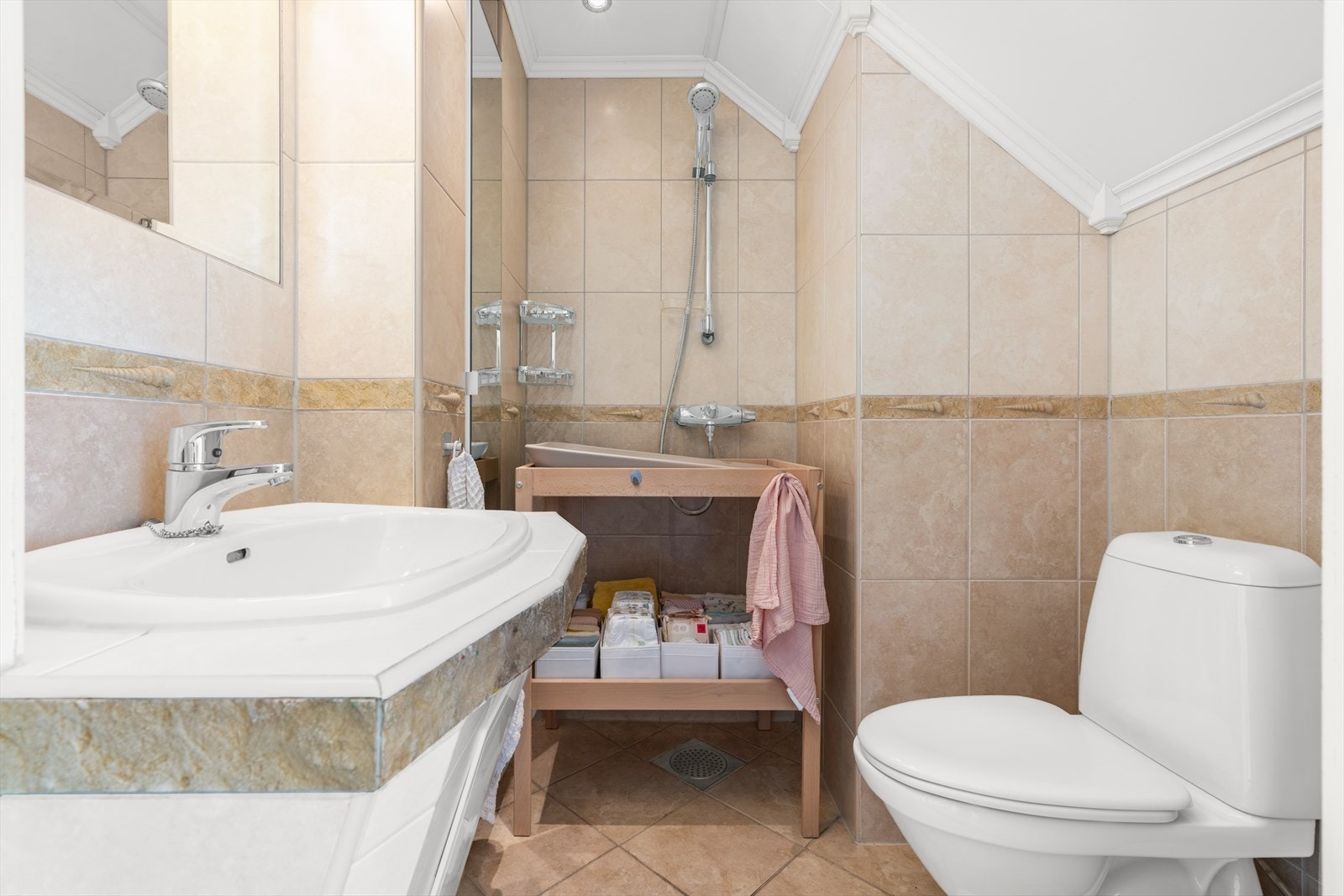 Flislagt baderom i hovedetasjen. Badet er eldre og brukes primært som stellerom og wc Galleribilde