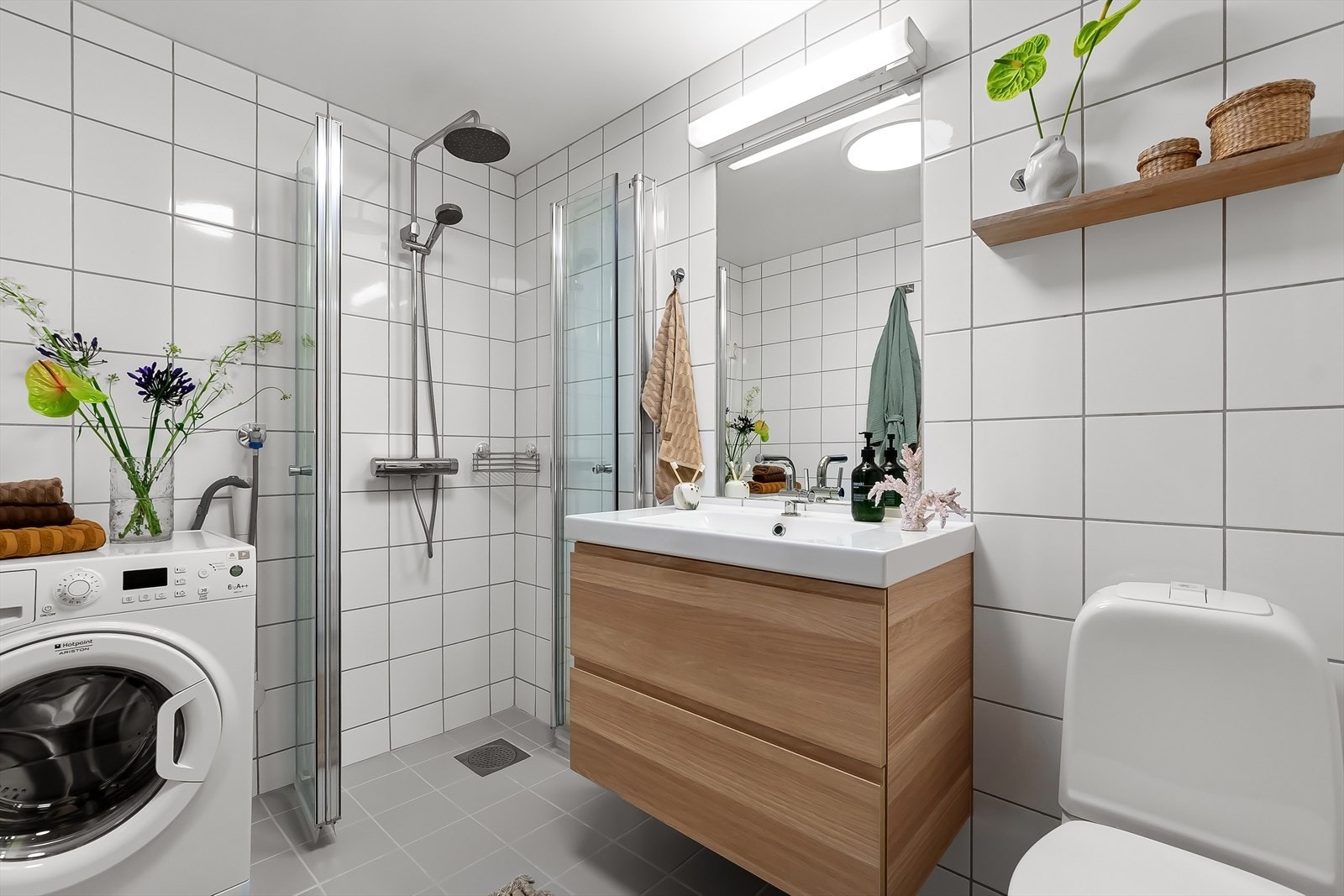 Badet er utstyrt med servantskap, speil i vegg med lyslist over servant, veggskap, klosett og dusjhjørne. Galleribilde