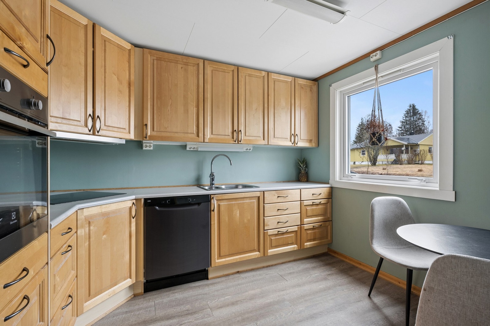 Kjøkkeninnredning med profilerte fronter og laminatbenkeplate. Rommet har plass til en spiseplass ved vinduet. Galleribilde
