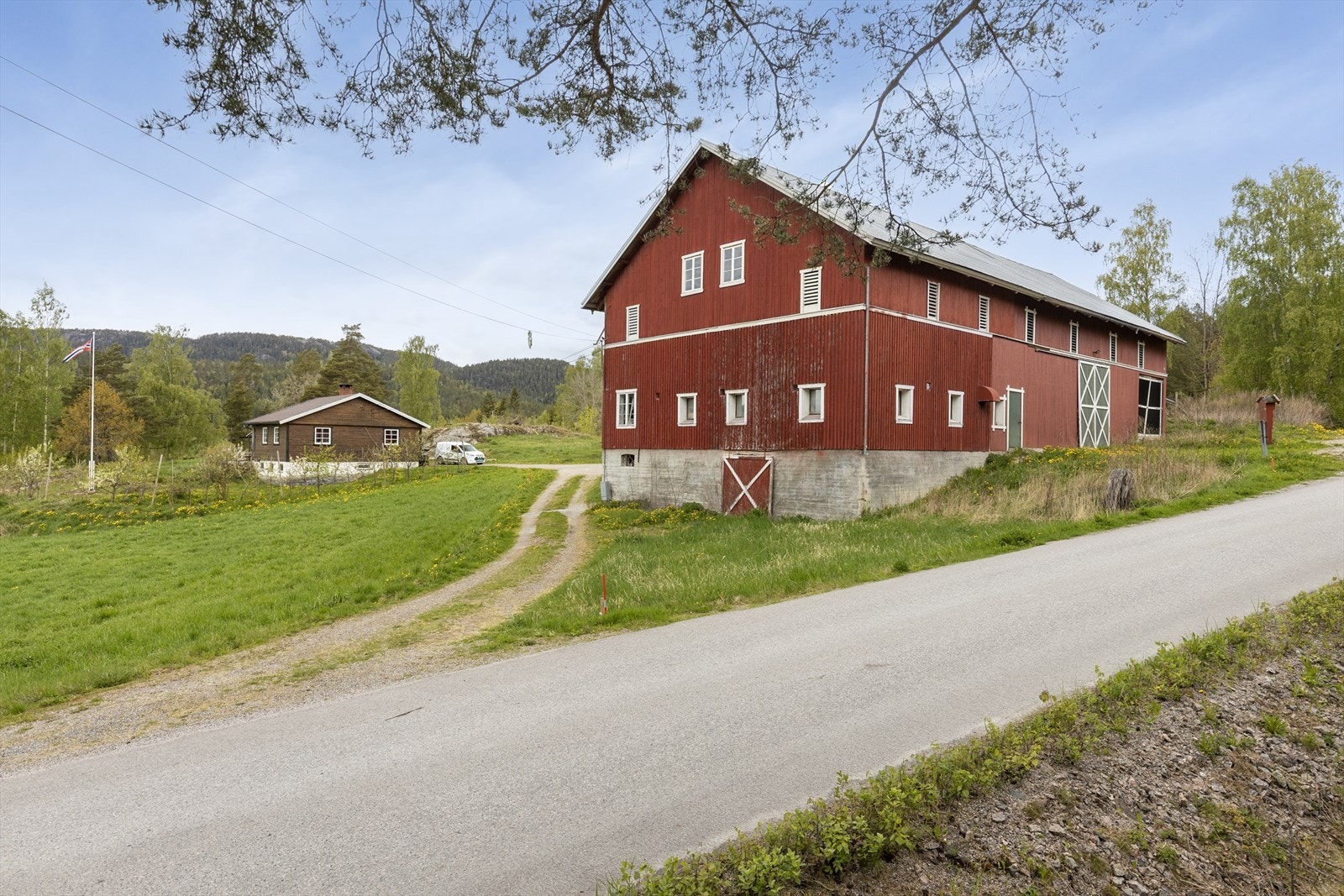 Eiendommen består av et våningshus og en stor driftsbygning. Galleribilde