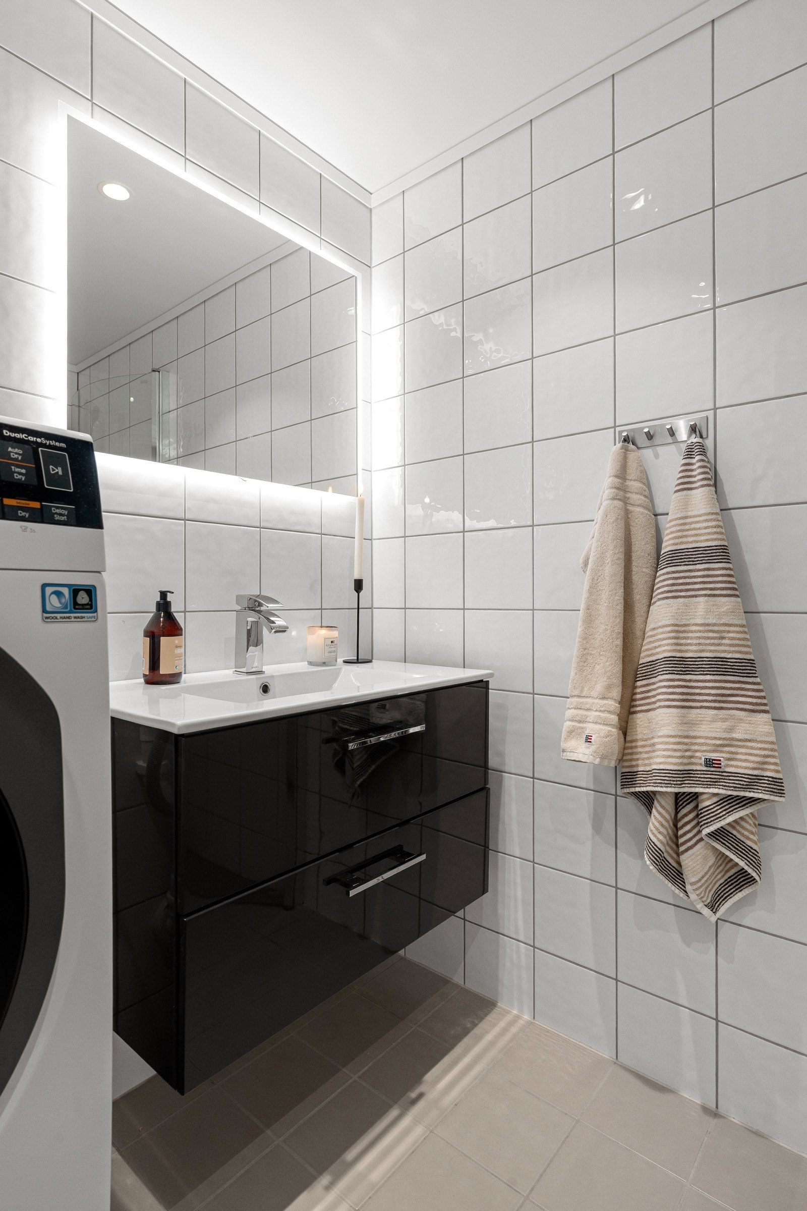 Badet fremstår moderne og det er opplegg til vaskemaskin.